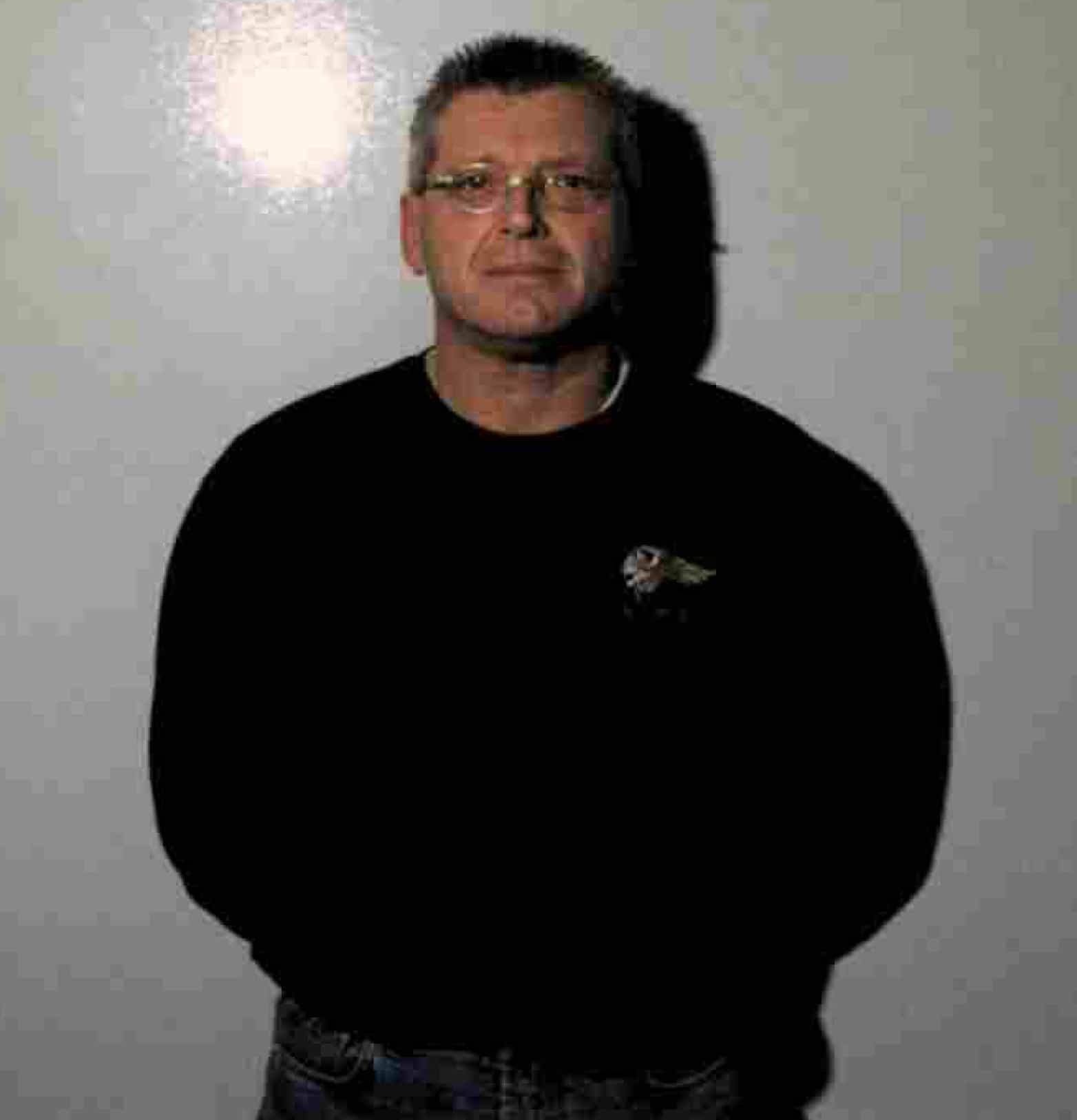 Maurice « Mom » Boucher, le chef des Hells Angels du chapitre Nomads, se fait photographier par les policiers qui souhaitent aussi documenter ses nombreux tatouages à l'effigie des Hells Angels, à la suite de sa deuxième arrestation en prévision du second procès pour les meurtres des gardiens de prison Diane Lavigne et Pierre Rondeau, le 10 octobre 2000. COURTOISIE