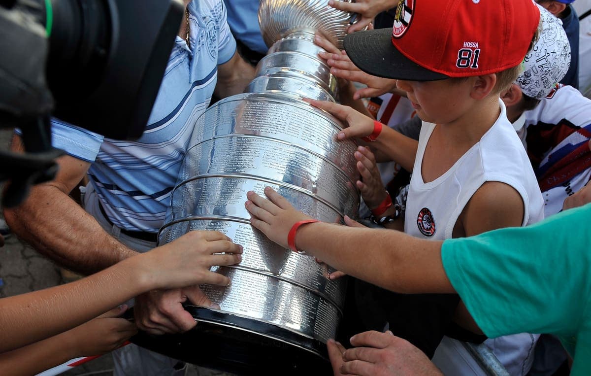 Des amateurs de hockey tiennent la coupe Stanley en Slovaquie, amenée par Michal Handzus après la victoire des Blackhawks de Chicago en 2013.