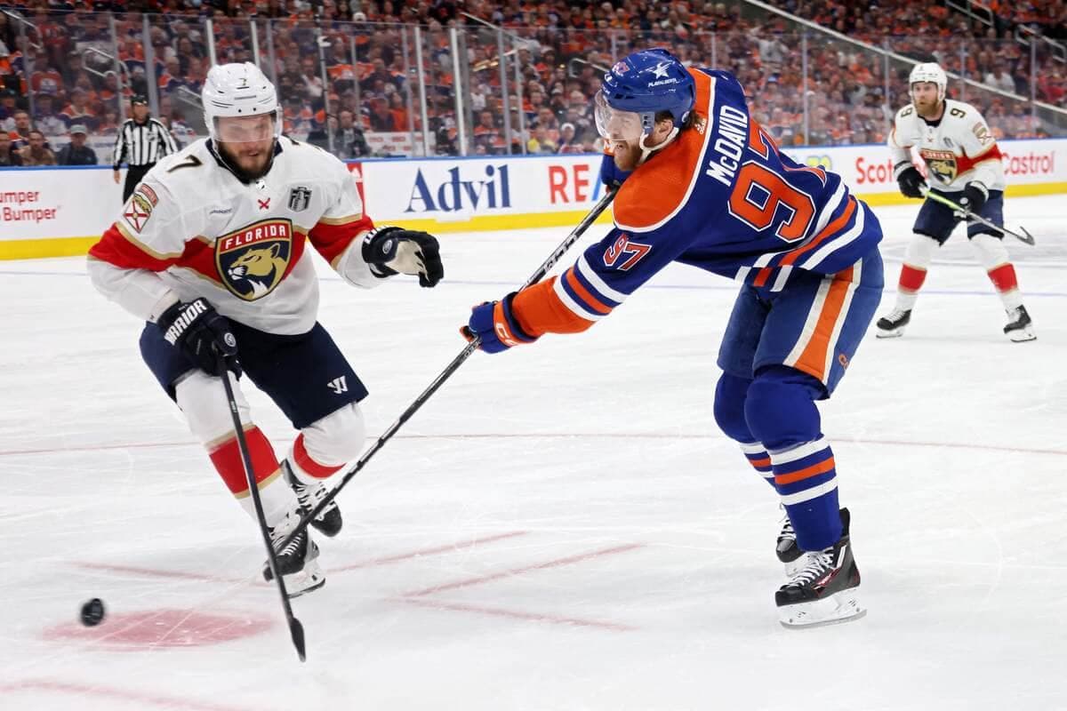 Dmitry Kulikov, en action, face à l'attaquant des Oilers Connor McDavid.