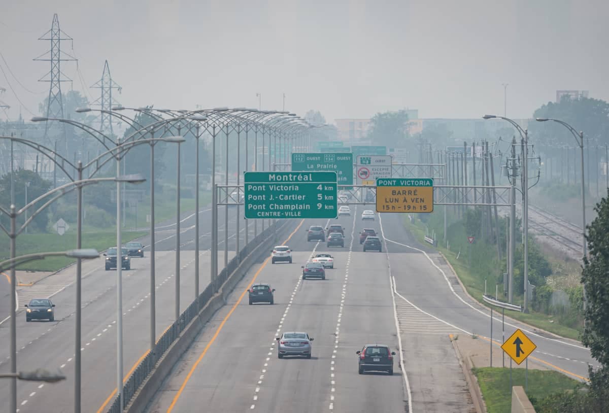 La route 116 et le centre-ville de Montréal habituellement visibles sont cachés par le smog.