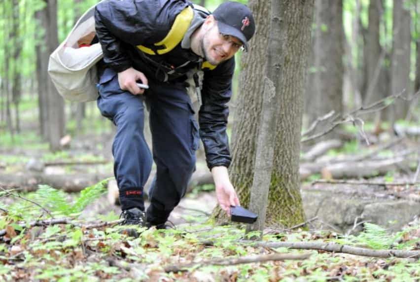 Le Dr Jérôme Pelletier distribue des appâts à souris à pattes blanches dans une forêt de l’Estrie. Ces appâts contiennent un poison à tiques inoffensif pour les mammifères.