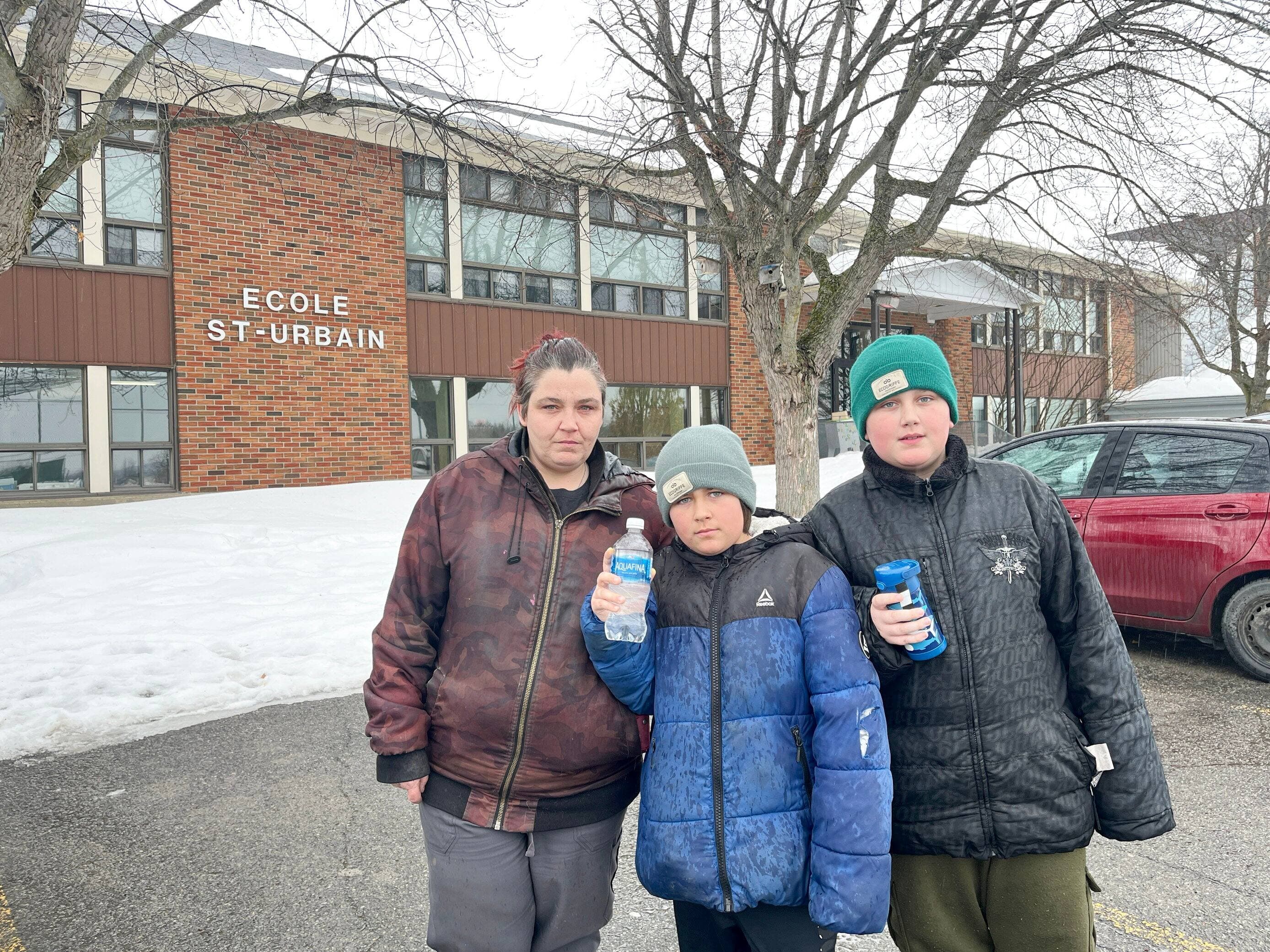 Yanna Gauthier et ses fils, Lyam et Nathan, qui fréquentent l’école Saint-Urbain. Ils tiennent leur bouteille d’eau, obligatoire à l’école depuis mars 2023.