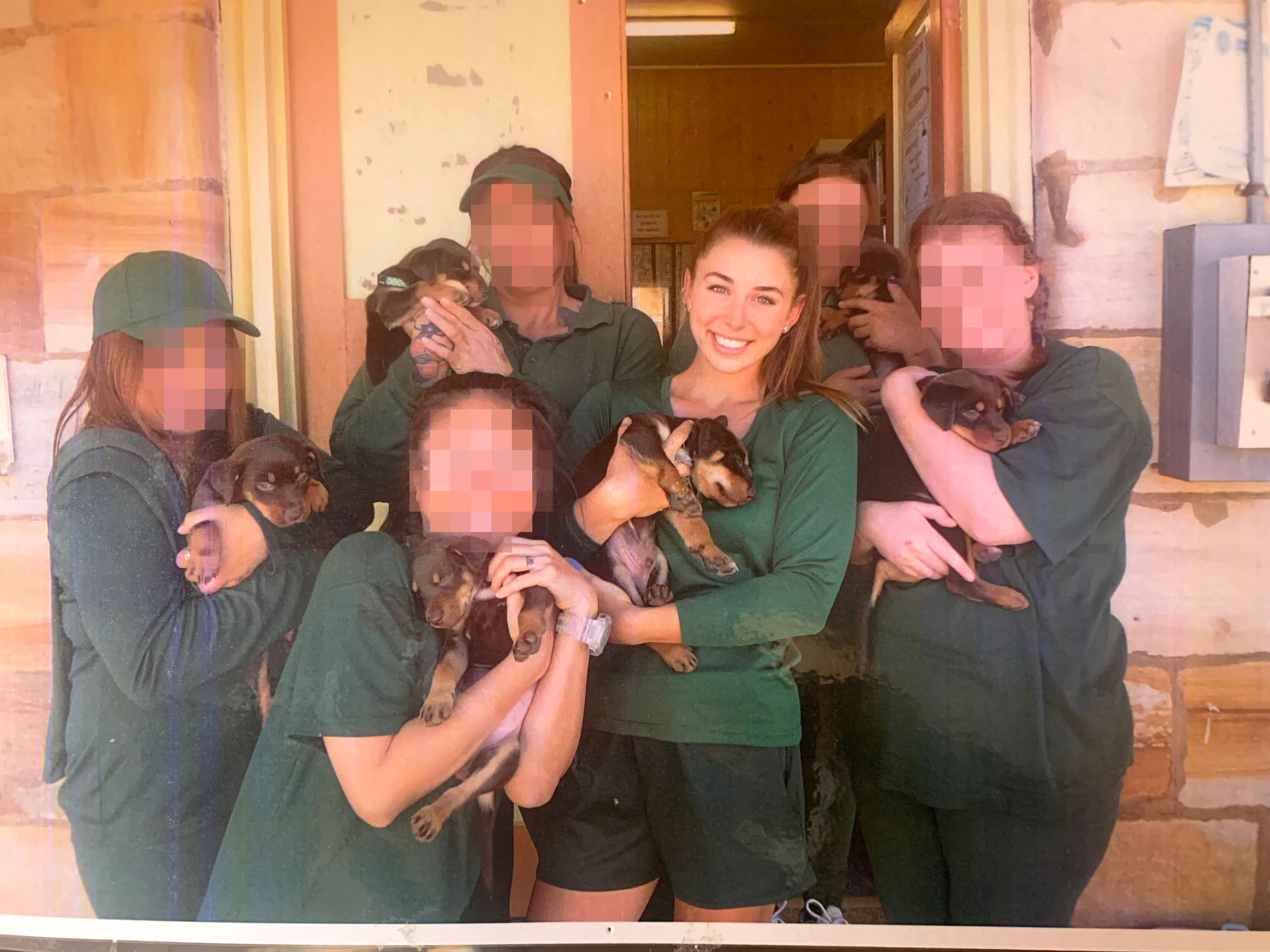 Mélina Roberge tient un chiot aux côtés d’autres détenues dans son uniforme vert forêt, à Berrima, un peu plus d’un an avant la fin de sa sentence. Une employée chargée de la bibliothèque avait eu la permission d’apporter une portée de chiots à la prison.