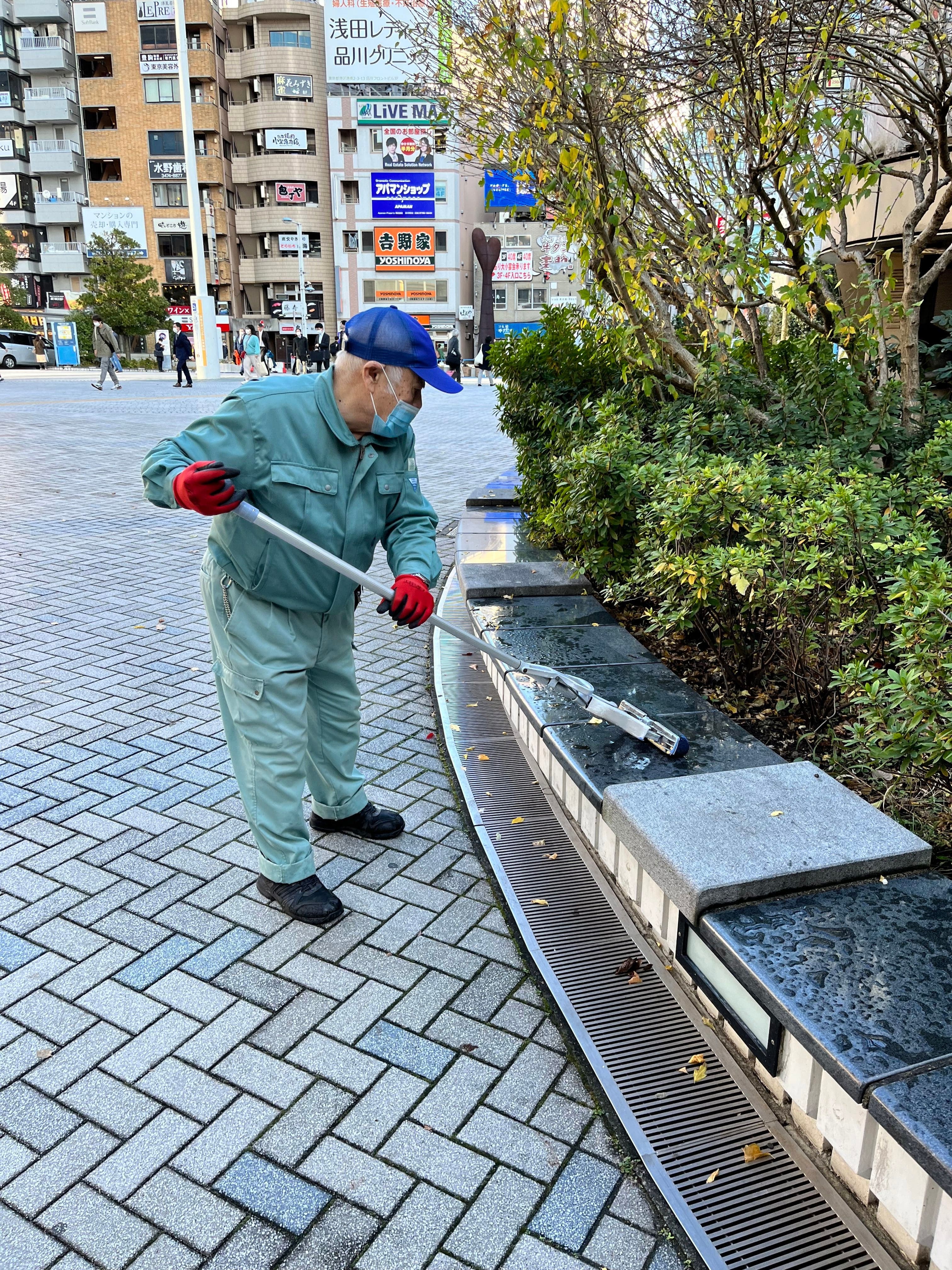 Un aîné nettoie un parc de Tokyo. Ils sont nombreux à travailler comme concierge ou gardien de sécurité.