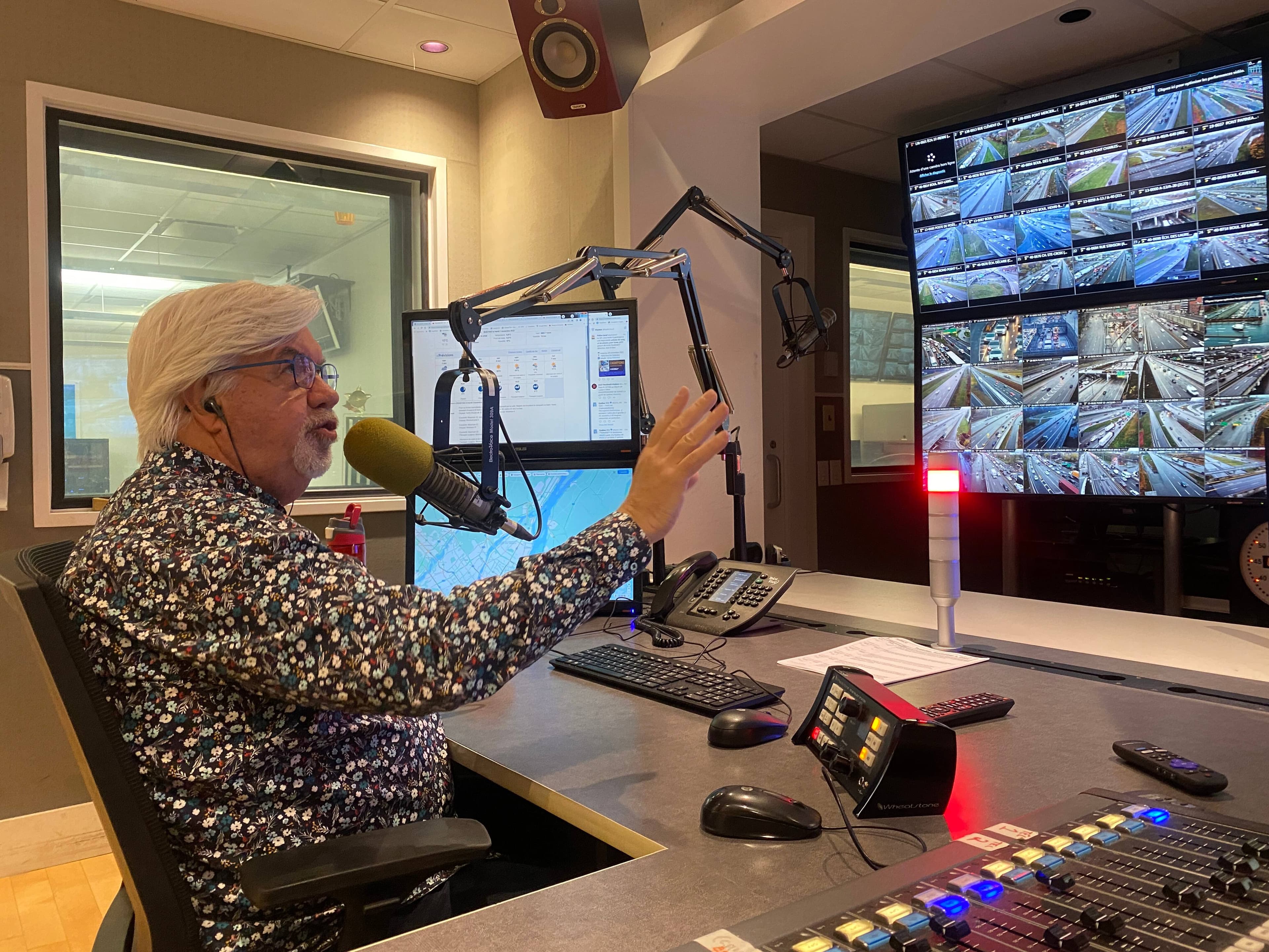 L’animateur Pierre Olivier en ondes dans le studio de Radio Circulation, où il peut observer les images de dizaines de caméras de surveillance sur les routes de la région métropolitaine.