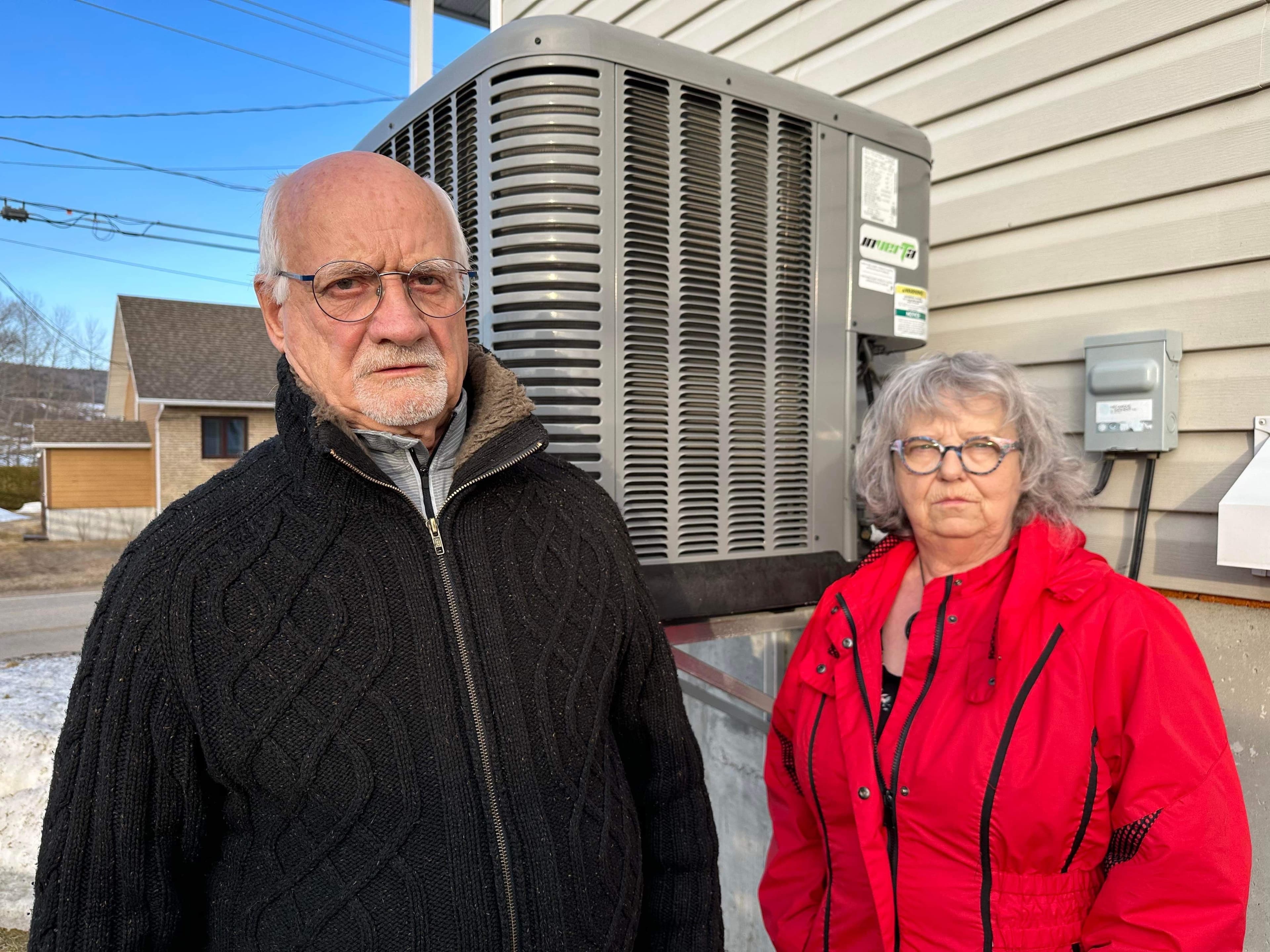 Michel Maltais et Michèle Tremblay devant leur thermopompe qui leur fait vivre toute une saga.