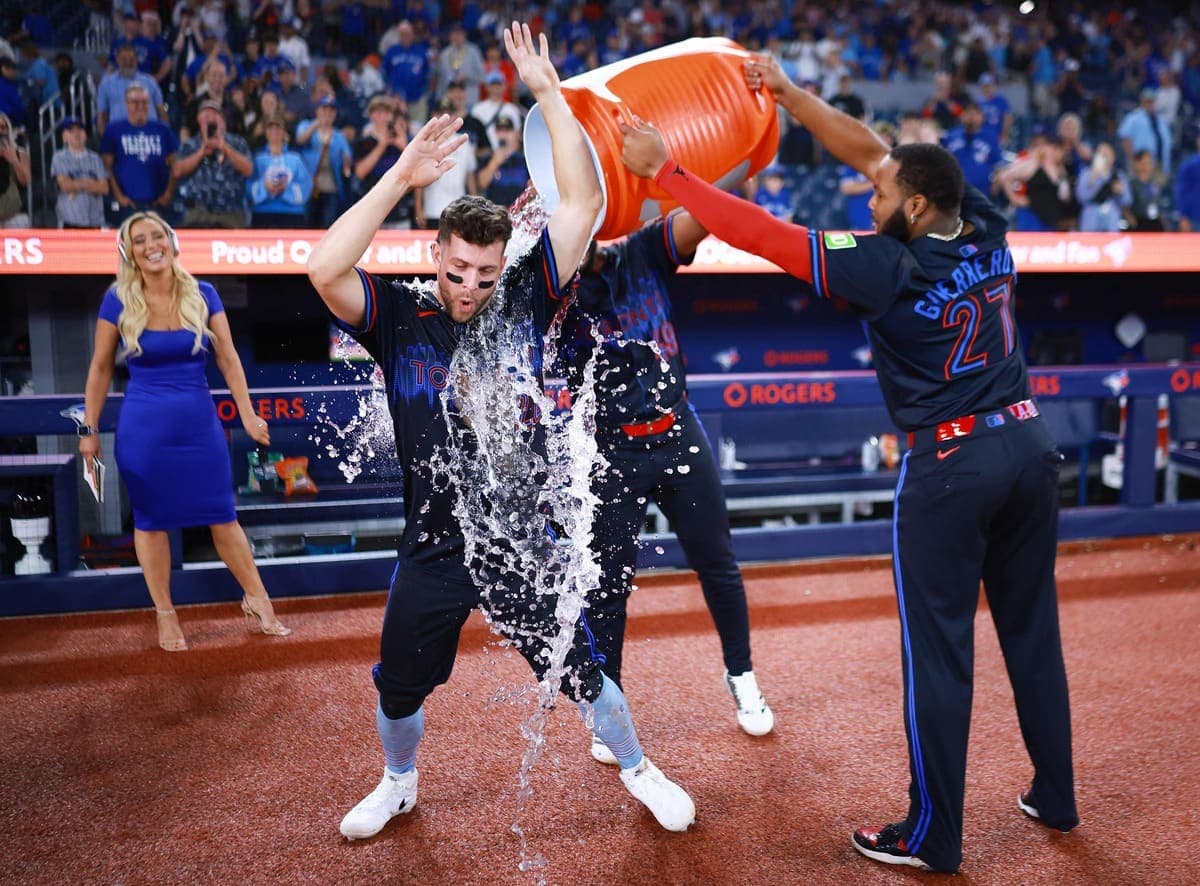 Vladimir Guerrero fils (à droite) arrose son coéquipier Ernie Clement après le match du 4 juillet dernier au Rogers Centre.