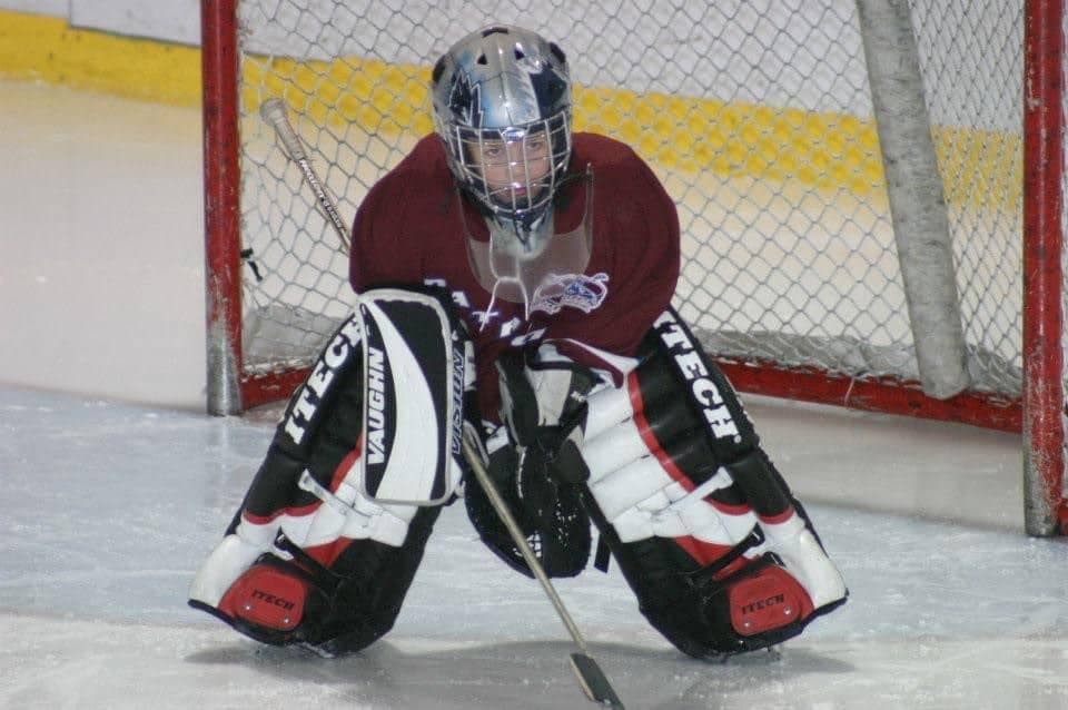 Samuel, à ses premiers pas devant un filet de hockey.