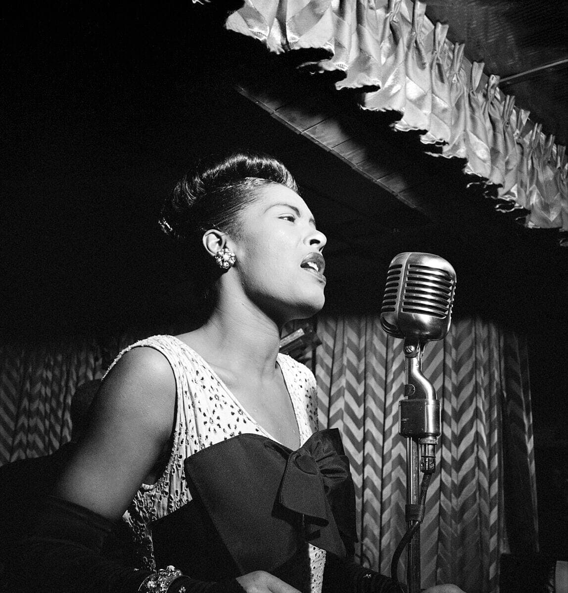 La chanteuse Billie Holliday en spectacle à New York en 1947. Elle est parmi les grandes vedettes du jazz à avoir chanté à Montréal.