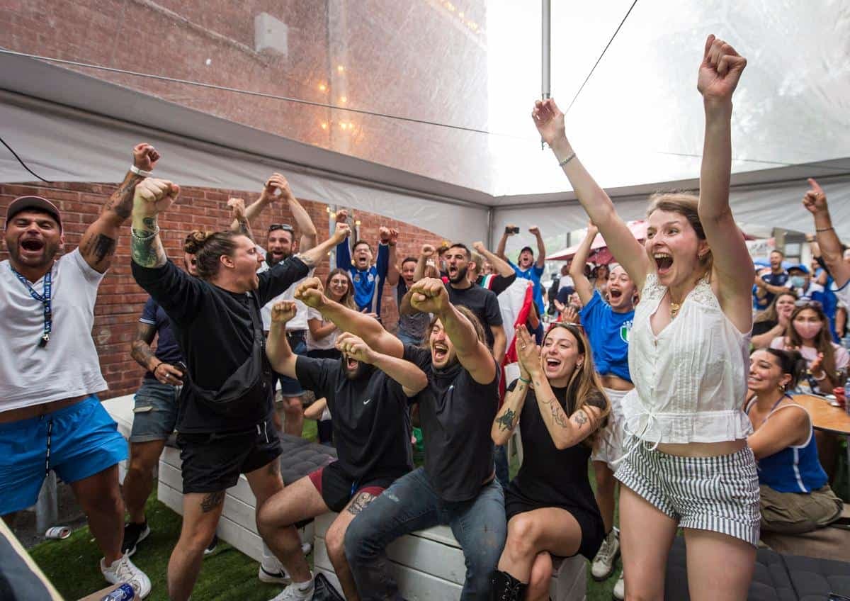 La foule célèbre le but vainqueur de l’Italie, qui accède ainsi à la finale de l’Euro, sur la terrasse du café Gelato.