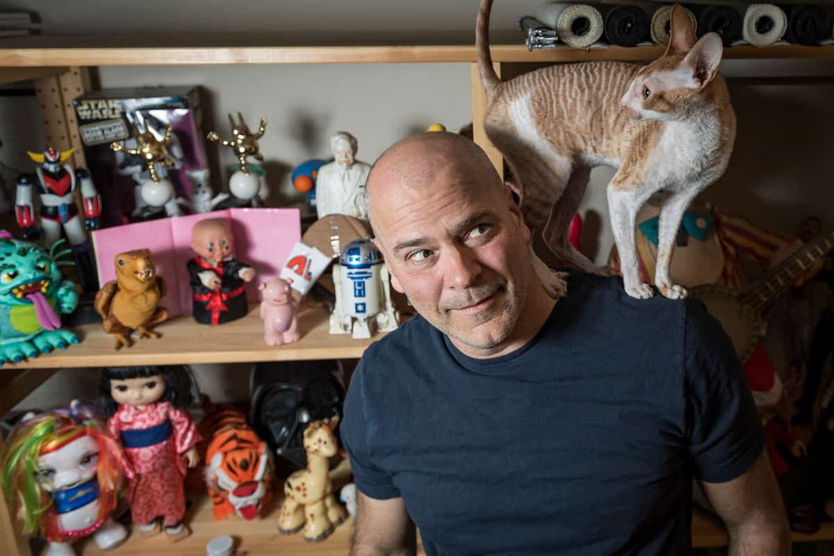 Daniel Grenier pose avec son chat Rav 4 dans « la pièce de la honte », qui comprend ses accessoires qui n'ont pas fonctionné sur scène.