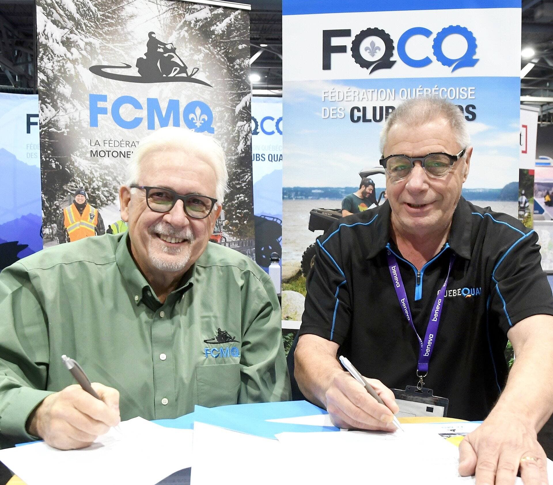 Le président de la Fédération des Clubs de motoneigistes du Québec, Réal Camiré (à gauche), et le président de la Fédération québécoise des Clubs Quads, Réjean Blouin (à droite), signent l’entente permettant le partage des sentiers.