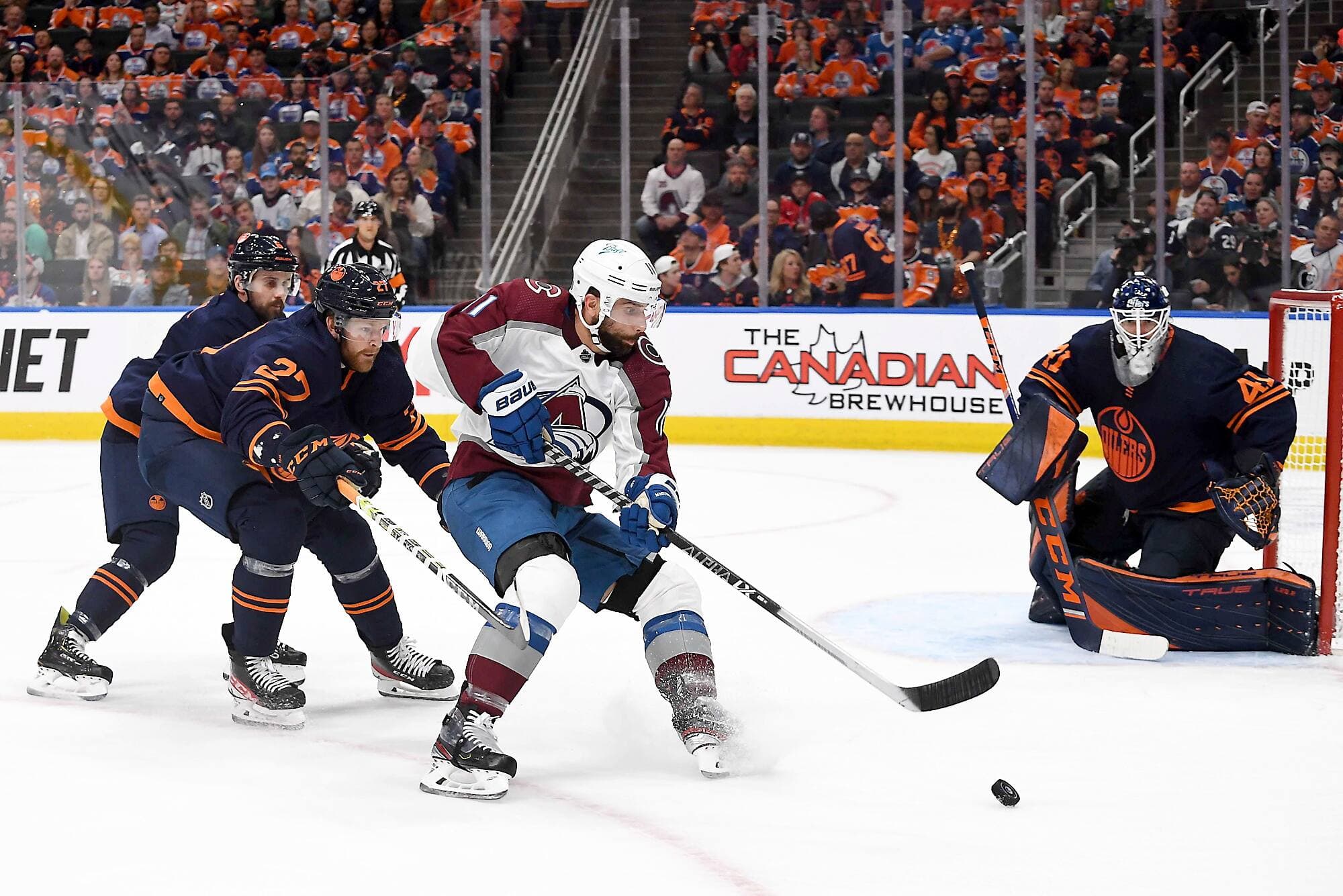 Brett Kulak pourchassant Andrew Cogliano lors du quatrième match de la série contre l’Avalanche du Colorado.