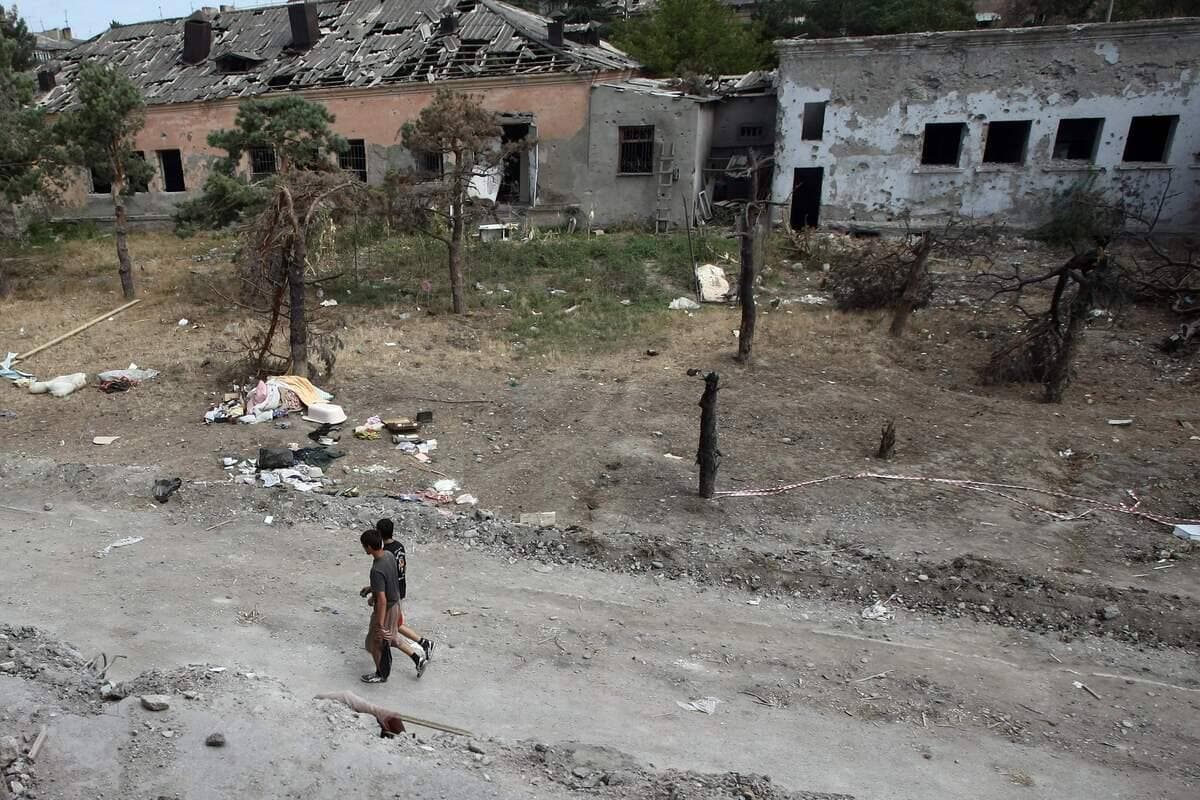 Deux jeunes Géorgiens marchent devant des ruines à Gori, ville géorgienne, le 4 septembre 2008.
