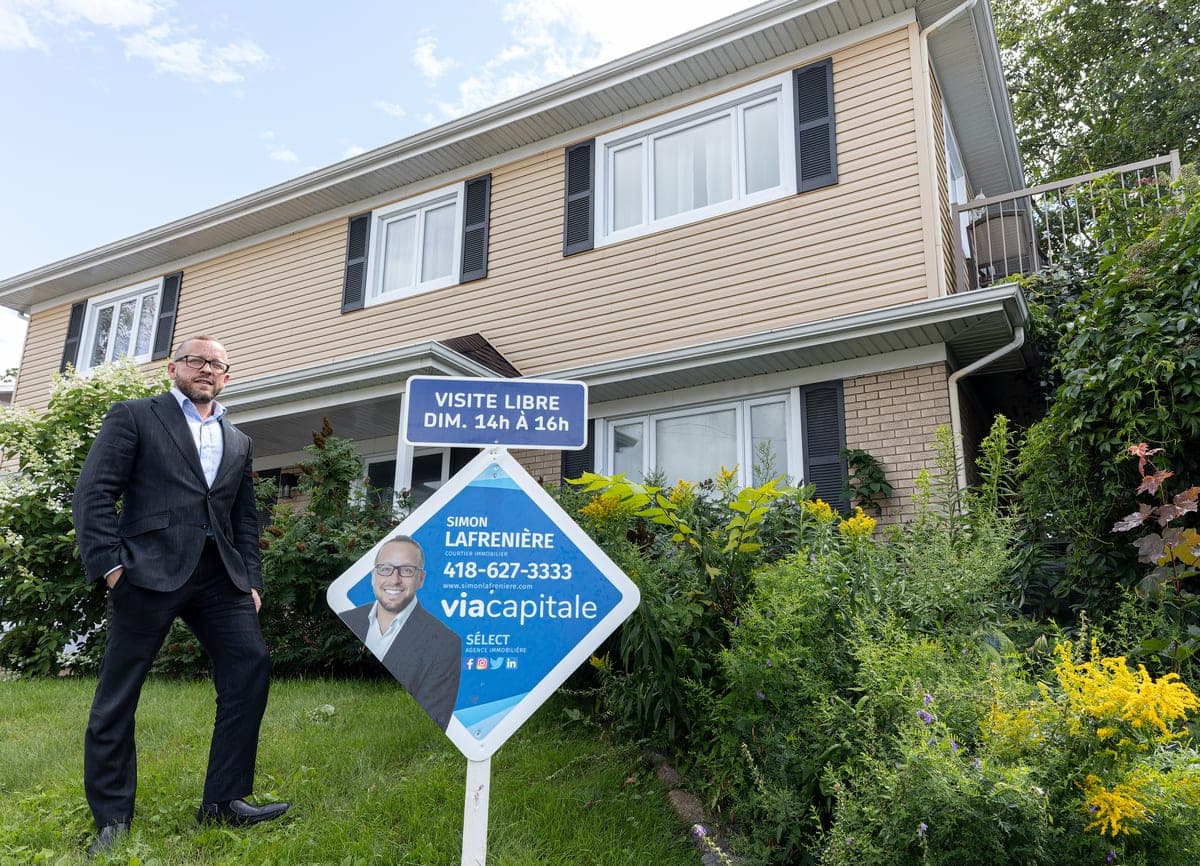 Simon Lafrenière, courtier immobilier pour Via Capitale, devant une propriété en vente le 9 août 2023.