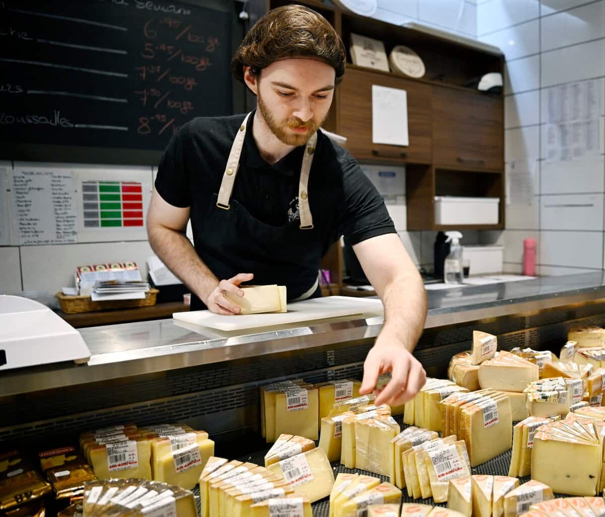Jonathan Fitzback-Fortin, de la fromagerie Aux Petits Délices aux Halles du Petit Cartier, place plusieurs fromages du Québec.