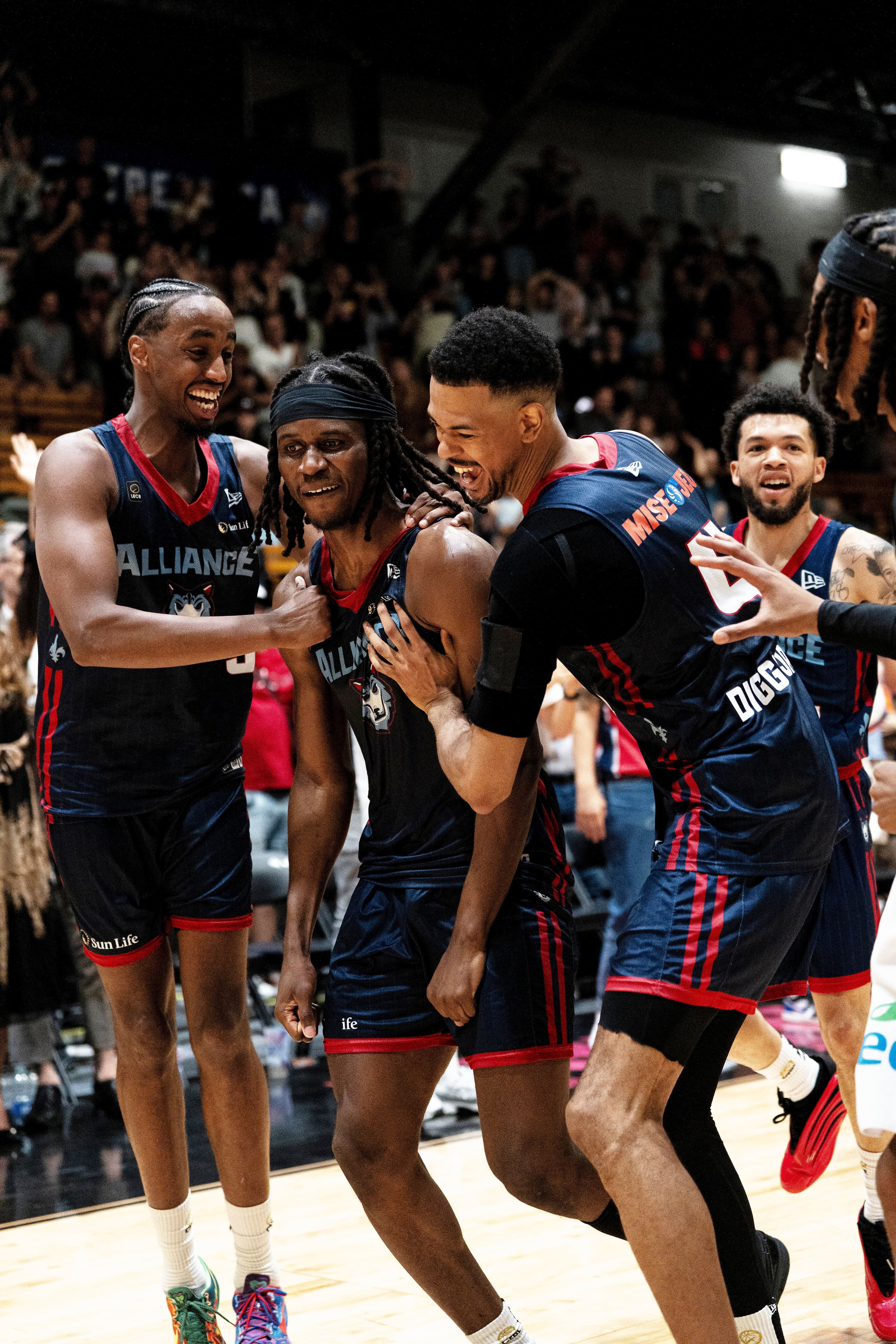 Kevin Osawe (au centre) est félicité par des coéquipiers pour son dunk gagnant qui a propulsé l'Alliance de Montréal en séries.