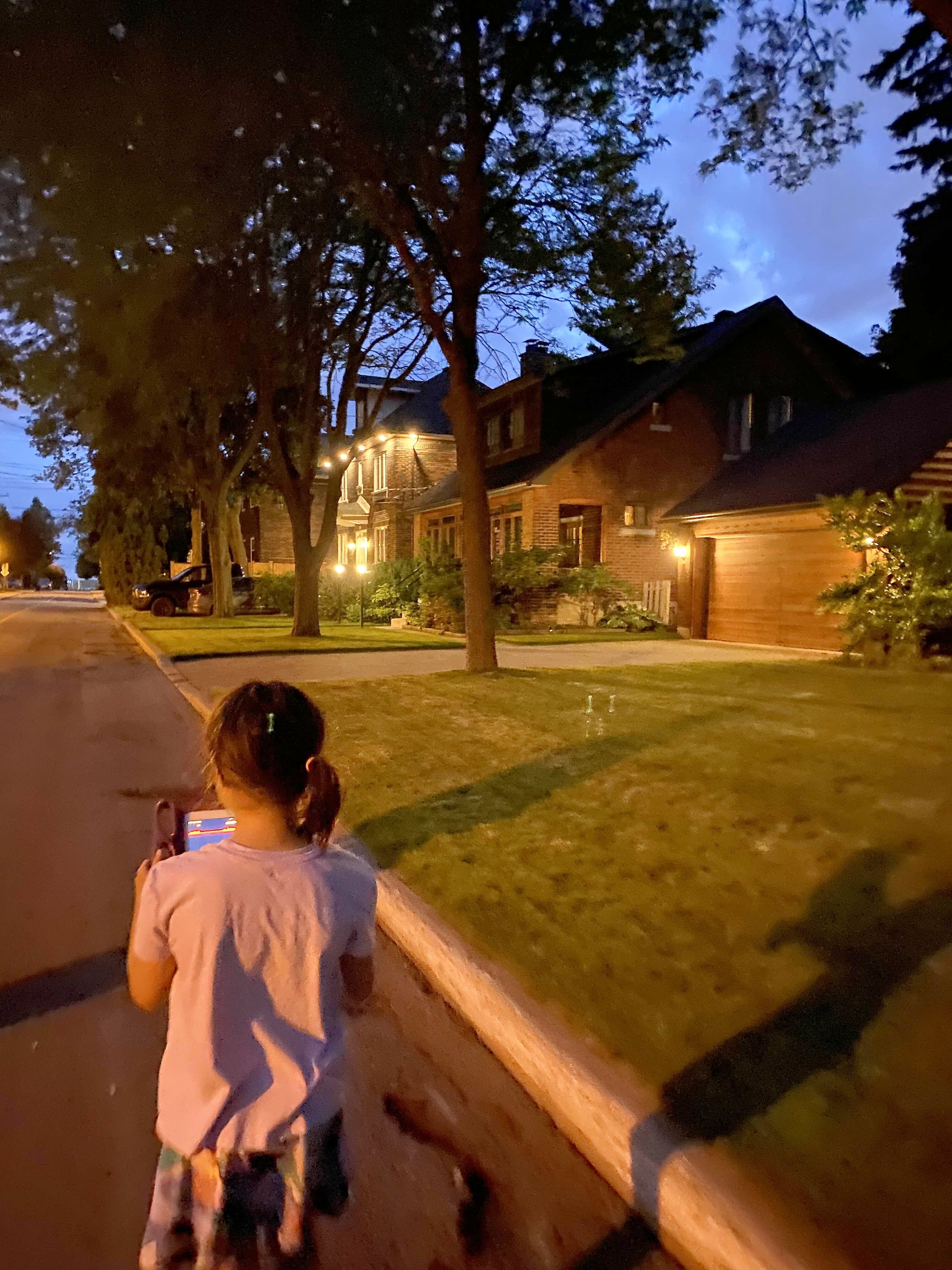 Une enfant qui note ses observations sur les lucioles sur une tablette lors d’une marche de recensement organisée par l’organisme Urbanature.