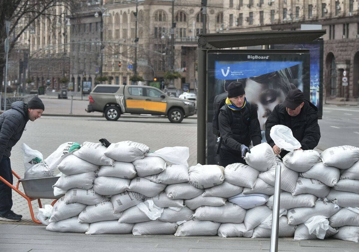 Des volontaires déposent des sacs de sable à l'entrée du métro de Kyïv.