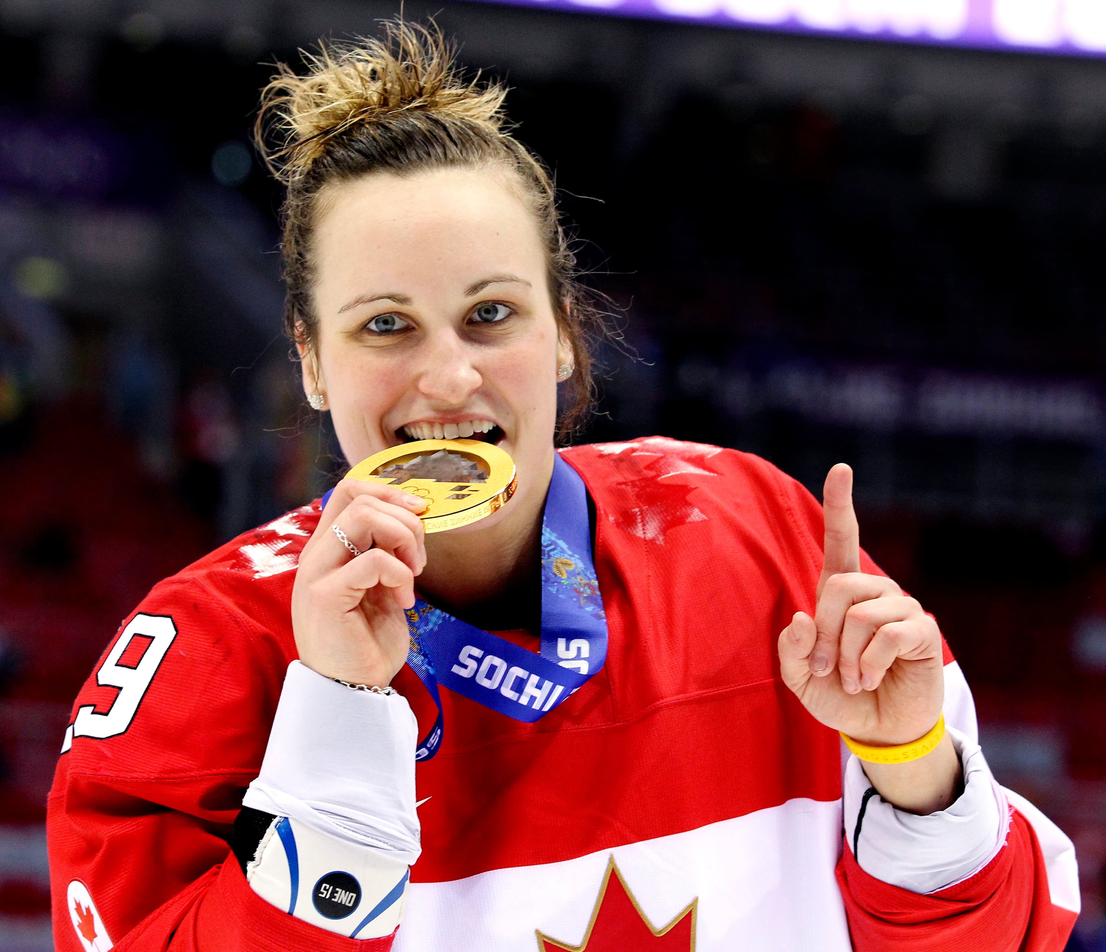 Marie-Philip Poulin croque dans sa médaille d'or lors des Jeux olympiques de Sotchi en 2014. Les canadiennes ont gagnées 3-2 contre l'équipe américaine.
