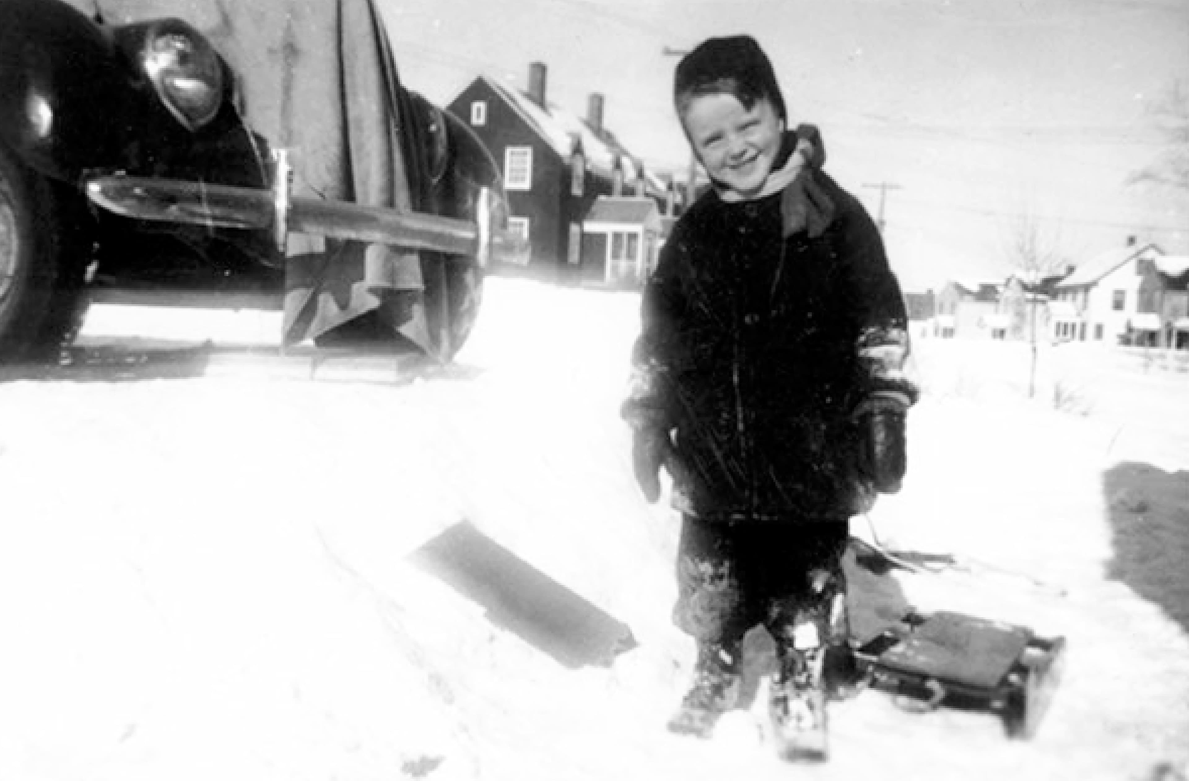 Un jeune Brian Mulroney devant sa maison, à Baie-Comeau, dans la neige.