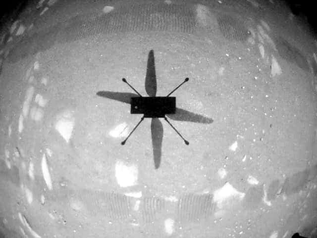 À l’occasion de son premier vol, le 19 avril 2021, Ingenuity envoie à la Terre cette image, montrant son ombre sur la planète.