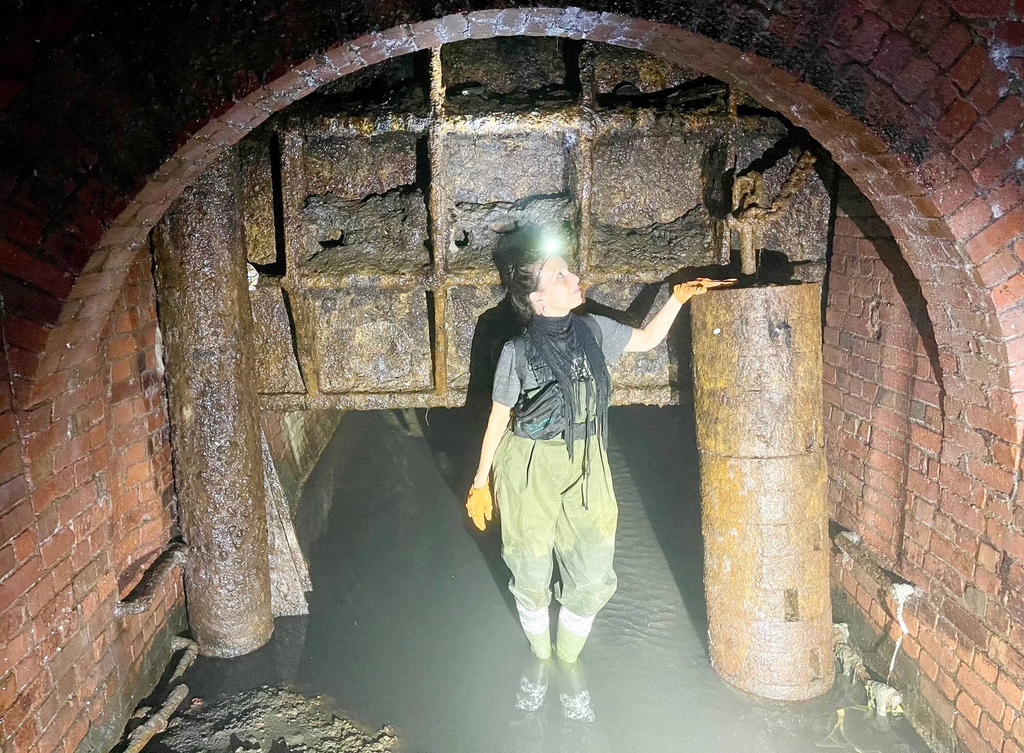 Danielle Plamondon se tient devant l’écluse qui empêchait jadis les eaux de refluer vers la ville lors des embâcles printaniers.