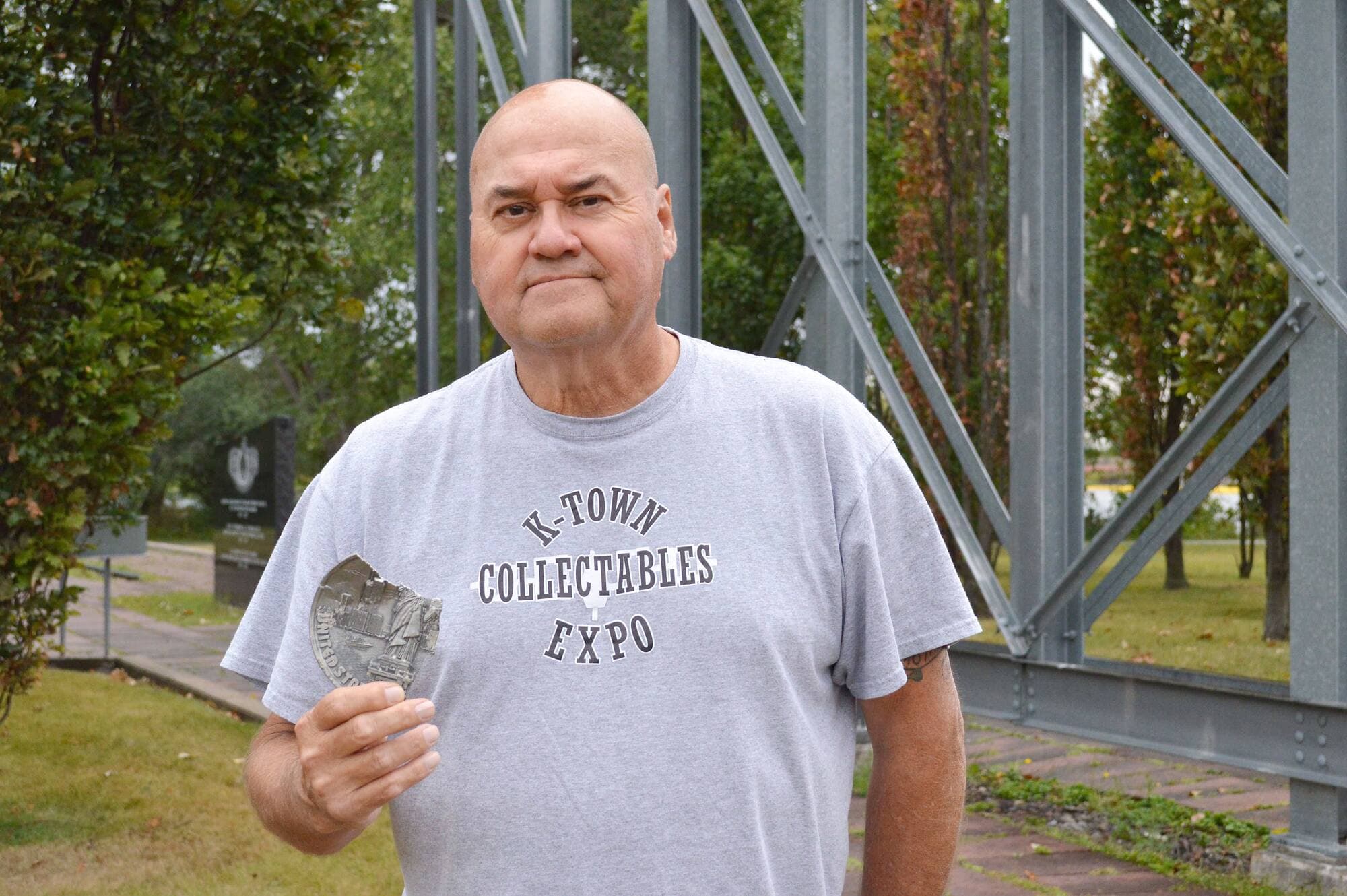 Lindsay LeBorgne tient une plaque abîmée qu’il a récupérée en nettoyant les décombres du World Trade Center.