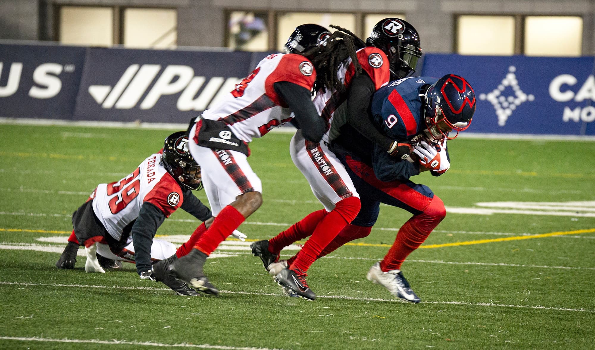 Sur cette séquence, le receveur de passes Jake Wieneke s’est fait arrêter par deux joueurs du Rouge et Noir, vendredi soir.