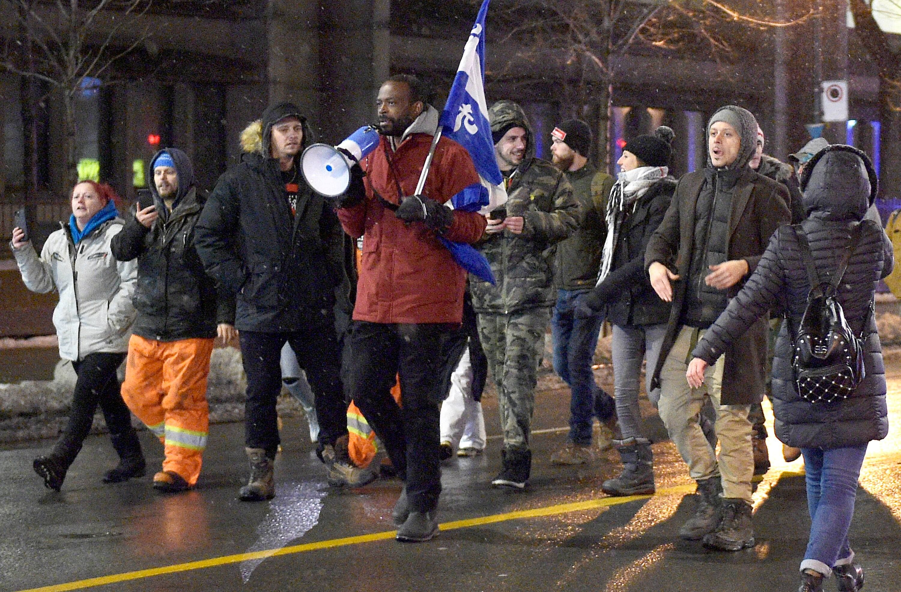 Une centaine de manifestants dénonçant les mesures sanitaires, dont l’increvable François Amalega Bitondo (au centre avec le porte-voix), ont marché samedi au centre-ville de Montréal.