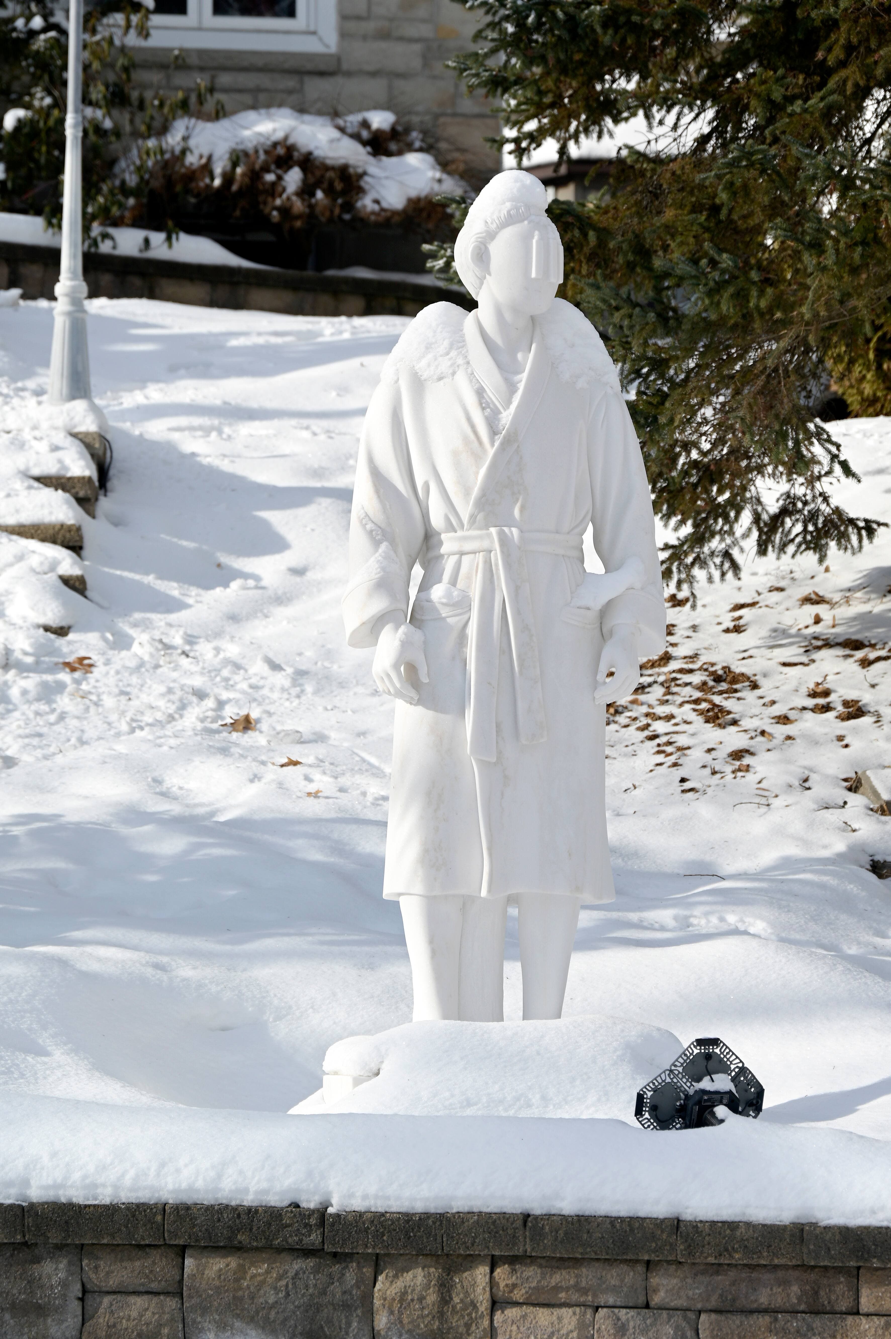 Une statue à l’effigie de James William Awad en peignoir devant une de ses six maisons, située sur la place du Coteau à Bois-des-Filion.