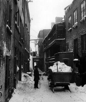 Un homme s’affaire au déneigement, rue Sous-le-Cap, à Québec, en 1895, au moyen d’une charrue tirée par un cheval.
