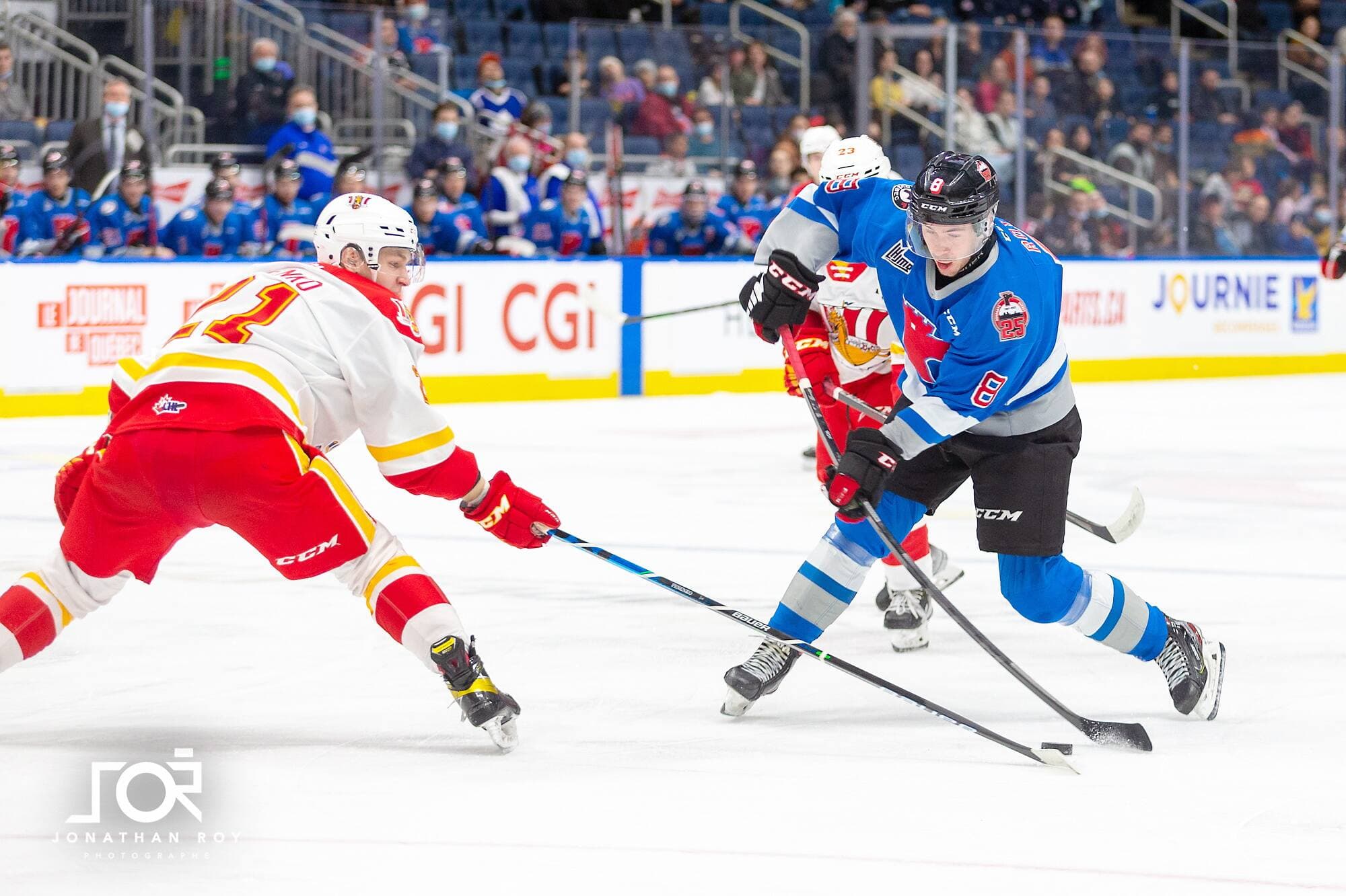 Pier-Olivier Roy (droite), des Remparts, tentant de déjouer un défenseur du Drakkar de Baie-Comeau, dimanche, au Centre Vidéotron de Québec.