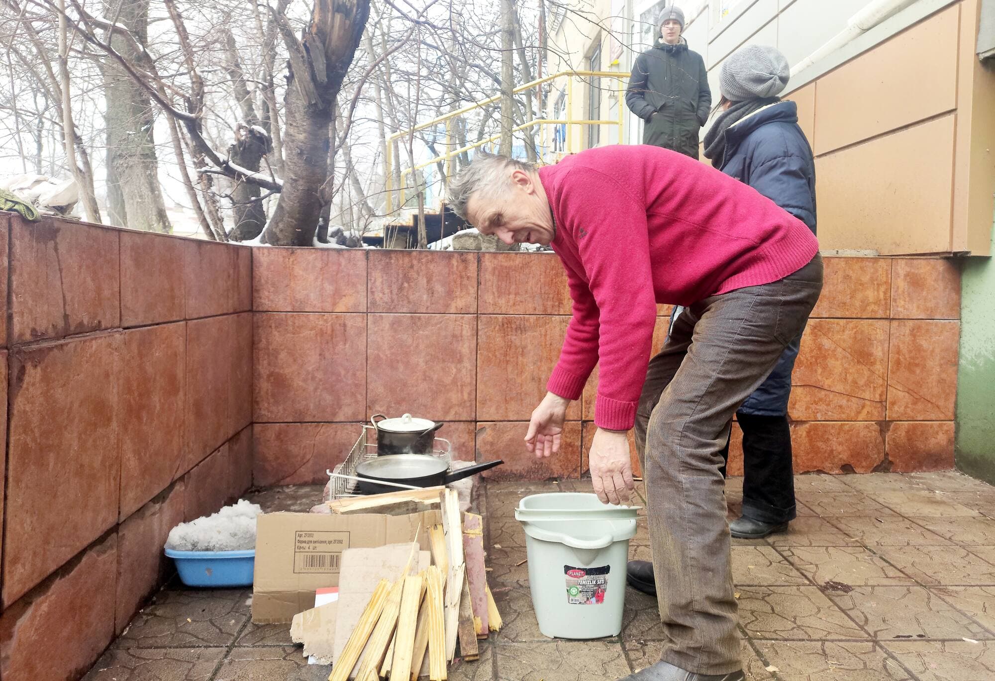 Le père de Glib Ivsieiev fait bouillir de l’eau sur un petit feu de bois à l’extérieur.