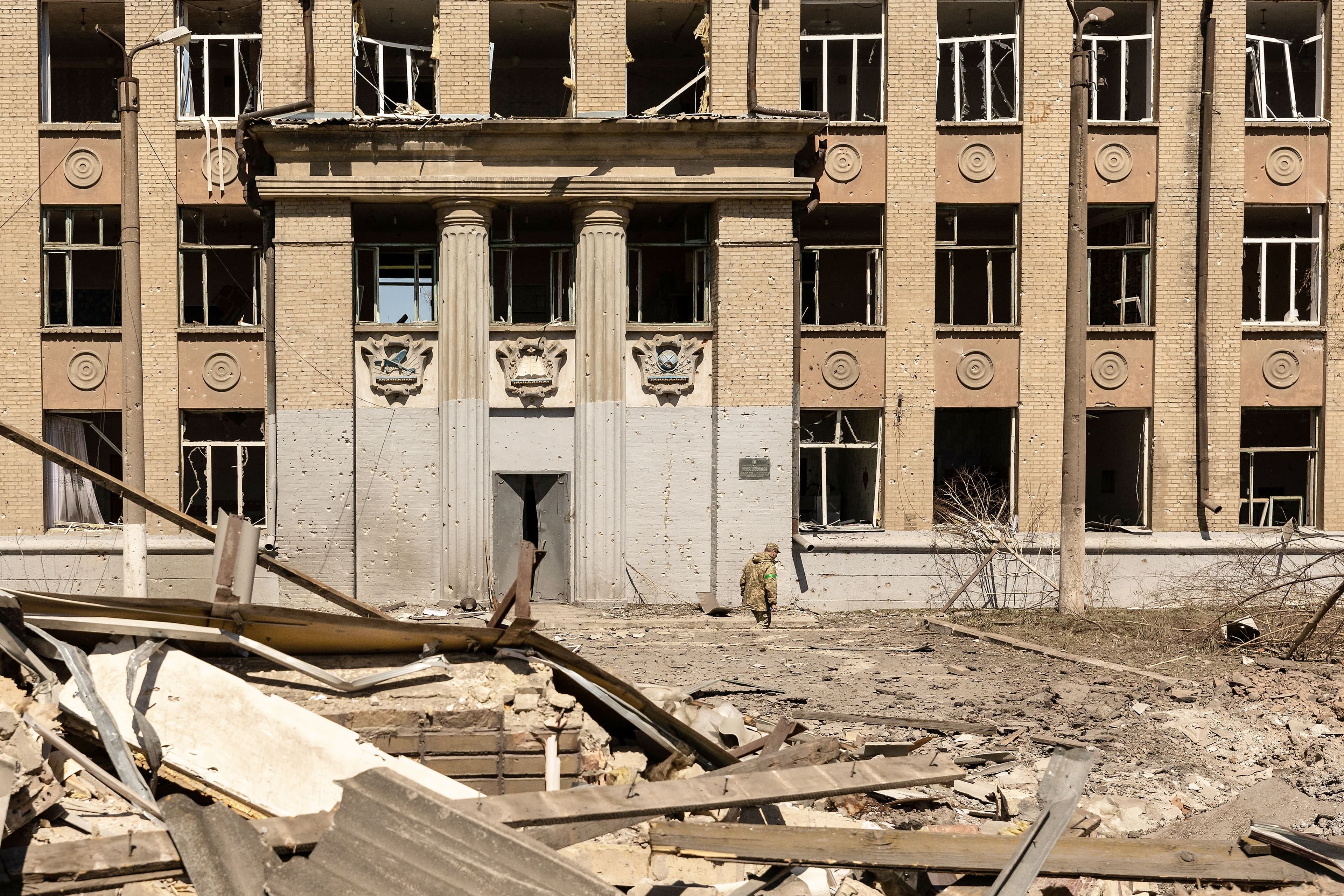 Un soldat ukrainien devant un bâtiment détruit de la région du Donetsk, à la suite d’une frappe russe.