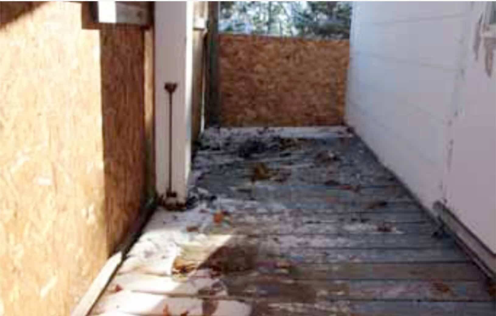 Le plancher de la galerie a certaines de ses planches de bois qui sont pourries et déformées