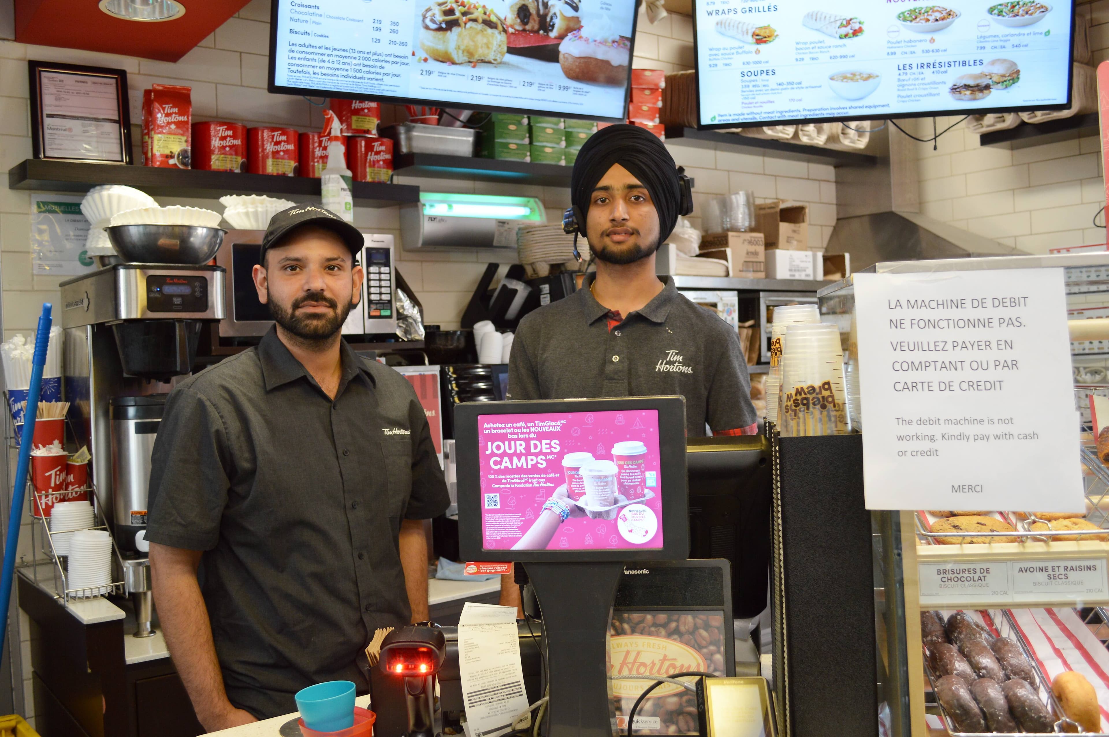 Le gérant du Tim Hortons du Marché Central, Inderpal Singh (à gauche), et son employé Jasmandeep Singh ont donné plusieurs produits, étant incapables d’offrir le paiement sur débit.