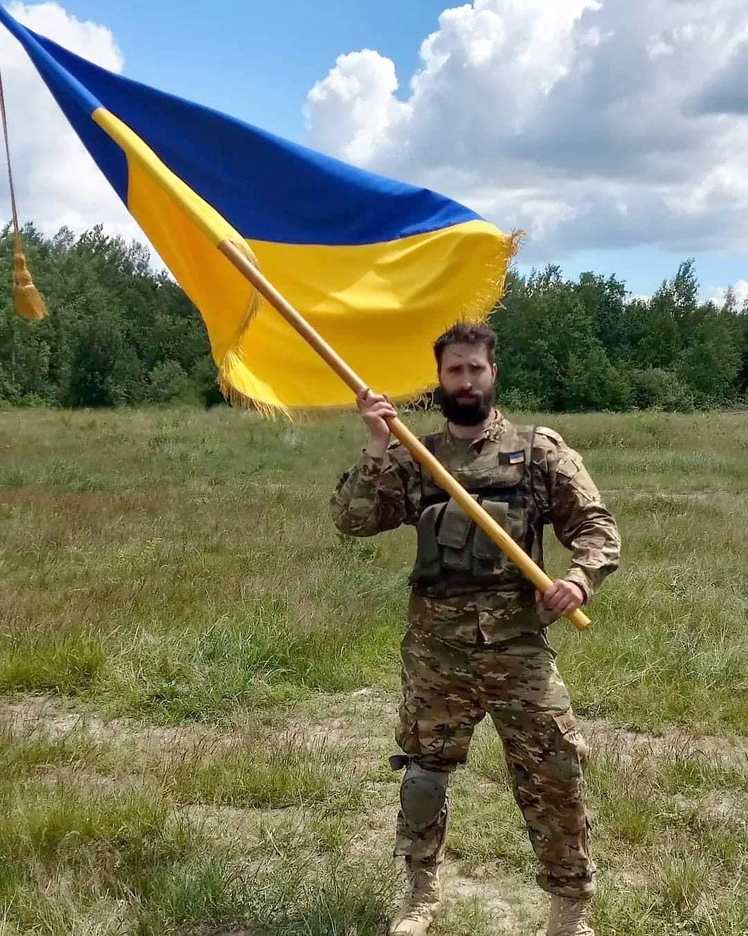 Le Montréalais tient un drapeau de l’Ukraine lors des entraînements militaires.