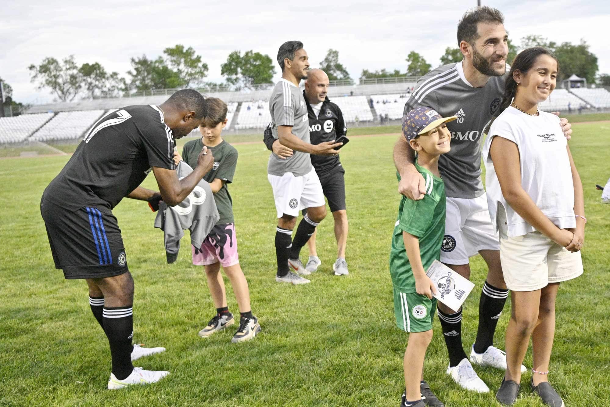 Un voyage dans le temps au centre Claude-Robillard, lundi. Patrice Bernier signe un chandail pendant que le légendaire Nacho Piatti (à droite) fait le bonheur de ces deux jeunes amateurs de soccer.