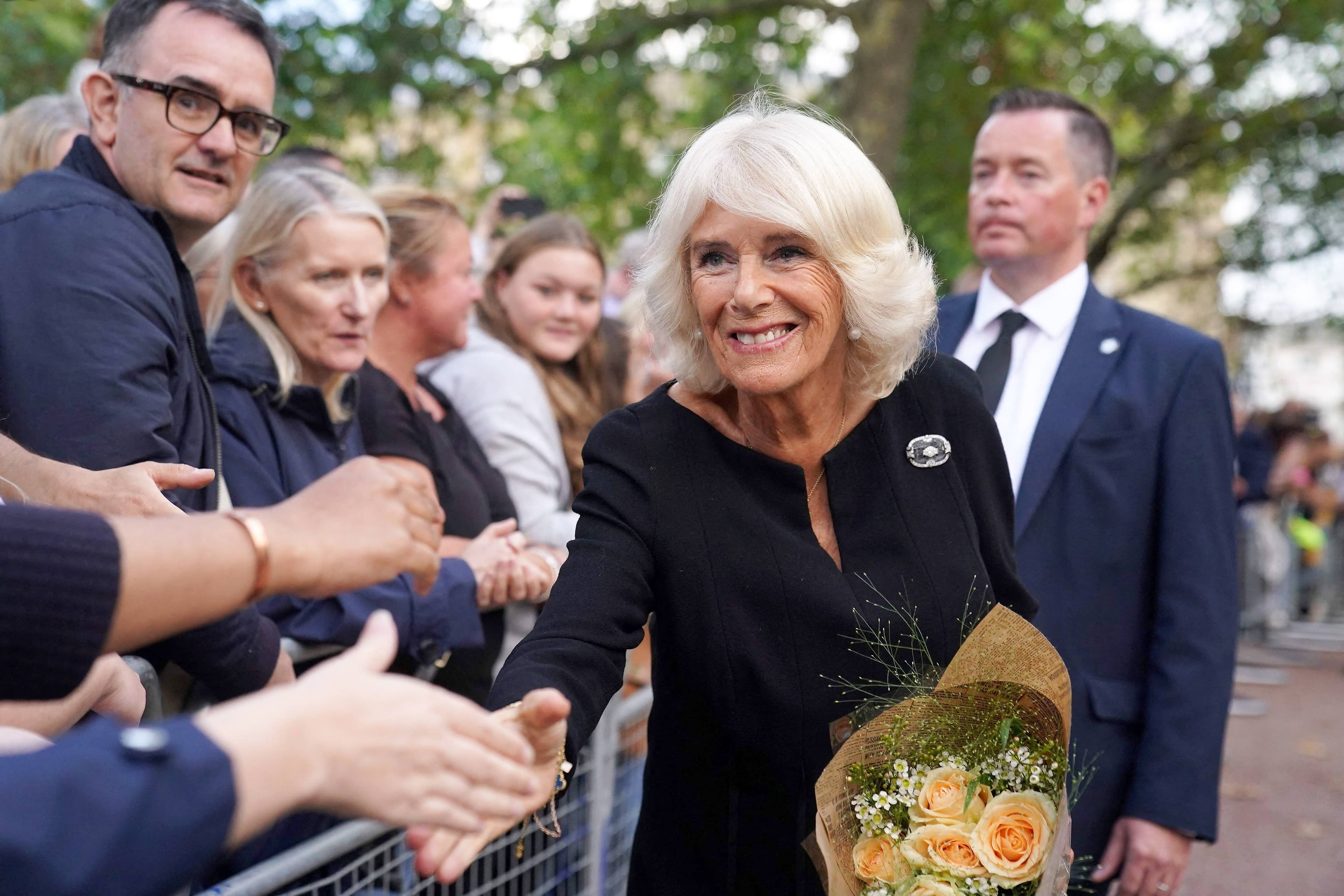 Camilla, saluant la foule réunie à Buckingham Palace, pour rendre hommage à la reine Elizabeth II, décédée le 8 septembre.