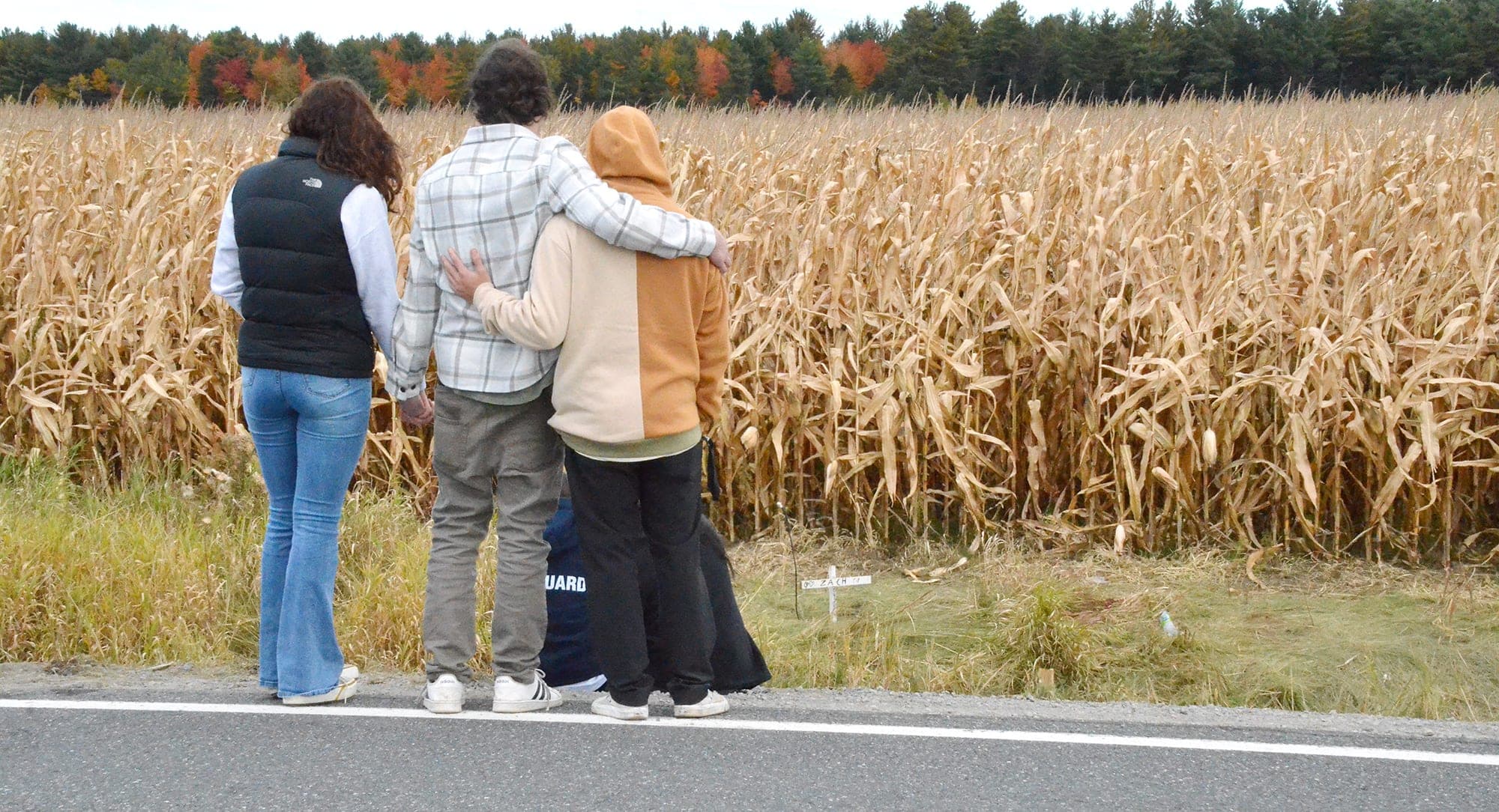 Des amis des victimes, dont Alexis Roy (manteau beige et orange), s’enlaçaient pour se soutenir dans cette épreuve, hier, à Saint-Robert devant les croix plantées pour leurs amis le long de la route 239.