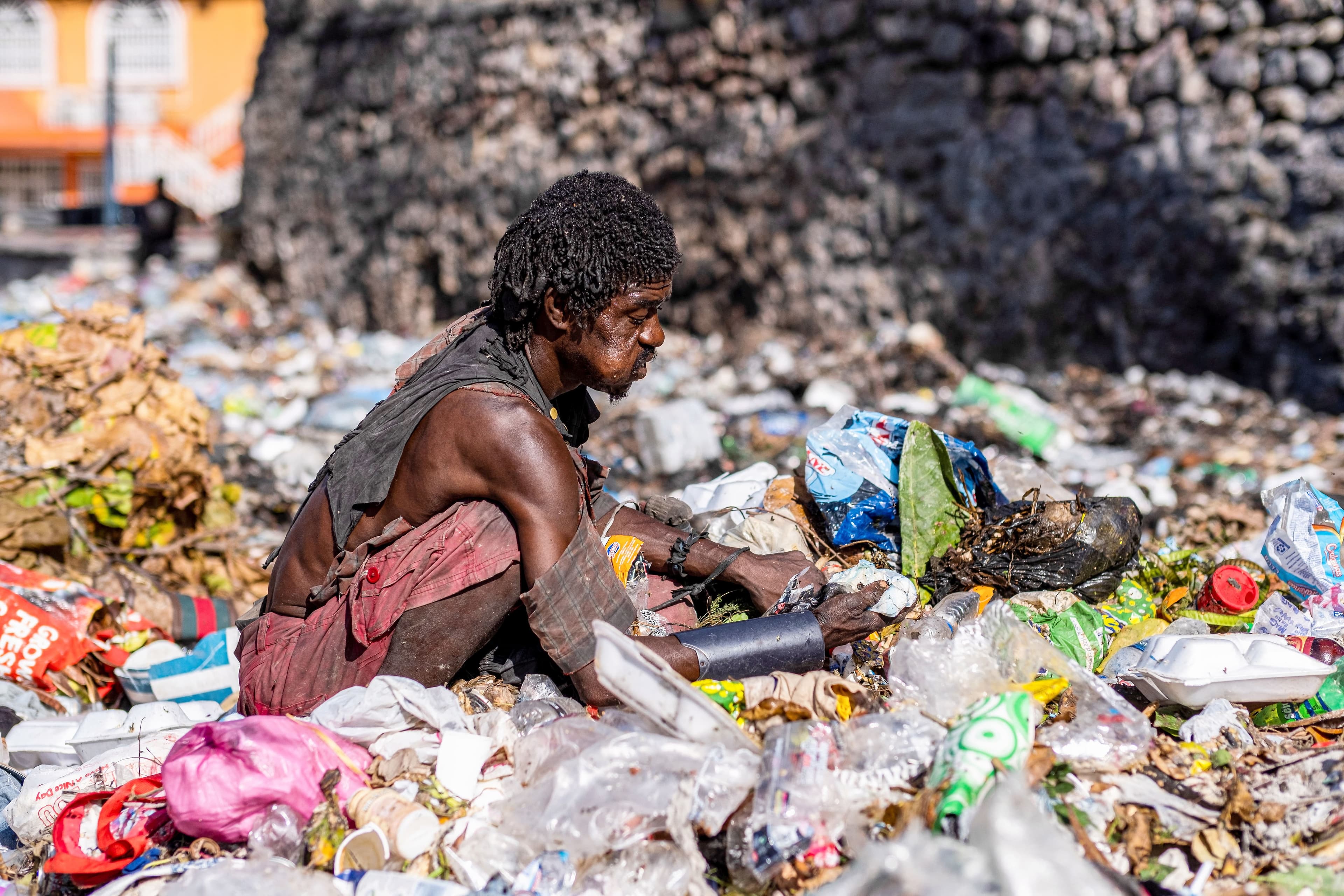Un homme cherche de la nourriture à travers les poubelles dans la capitale.