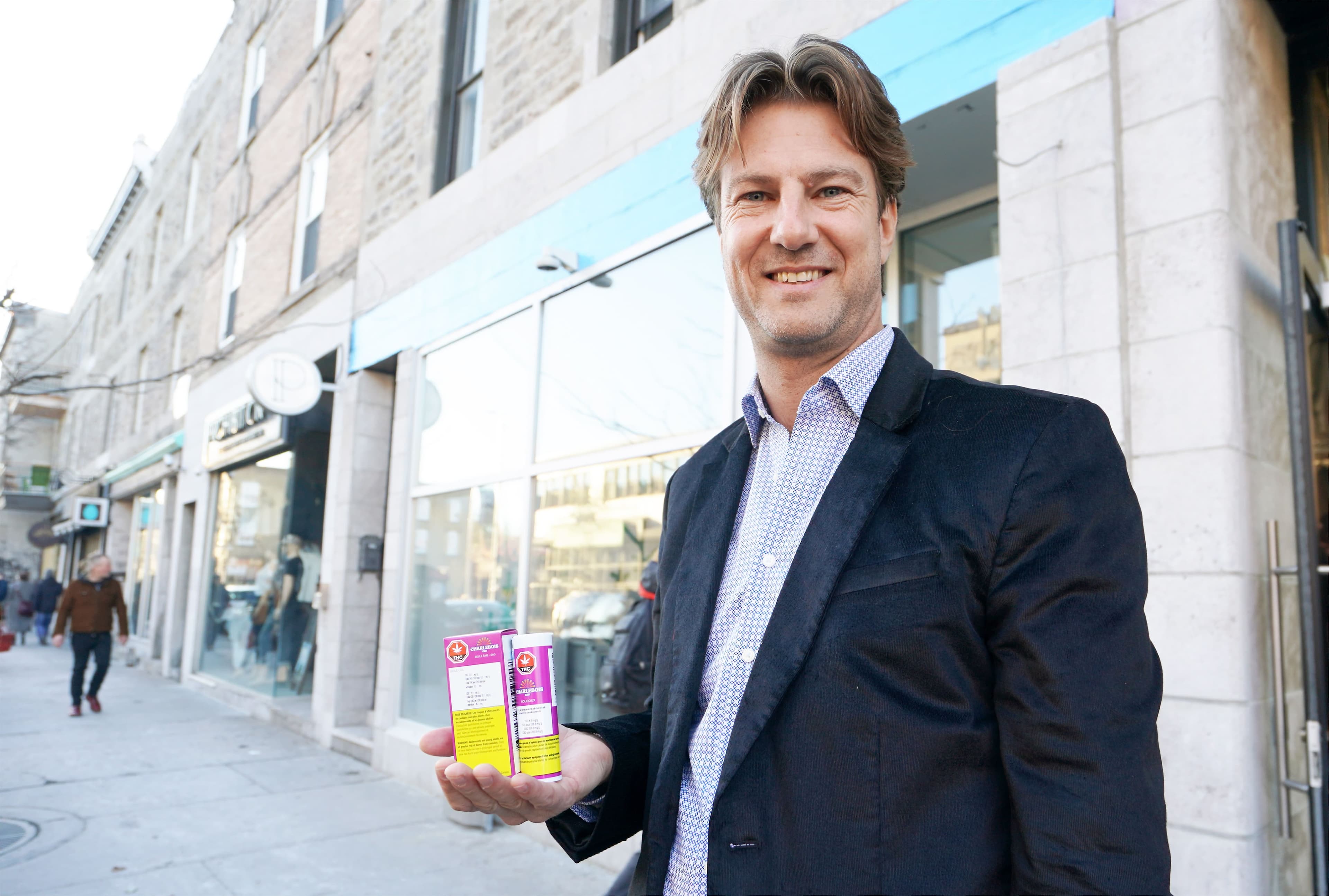 Victor Charlebois, samedi dernier, devant une SQDC de l’avenue du Mont-Royal Est, tient dans ses mains l’huile de CBD Belle Âme et les joints préroulés Roudoux.