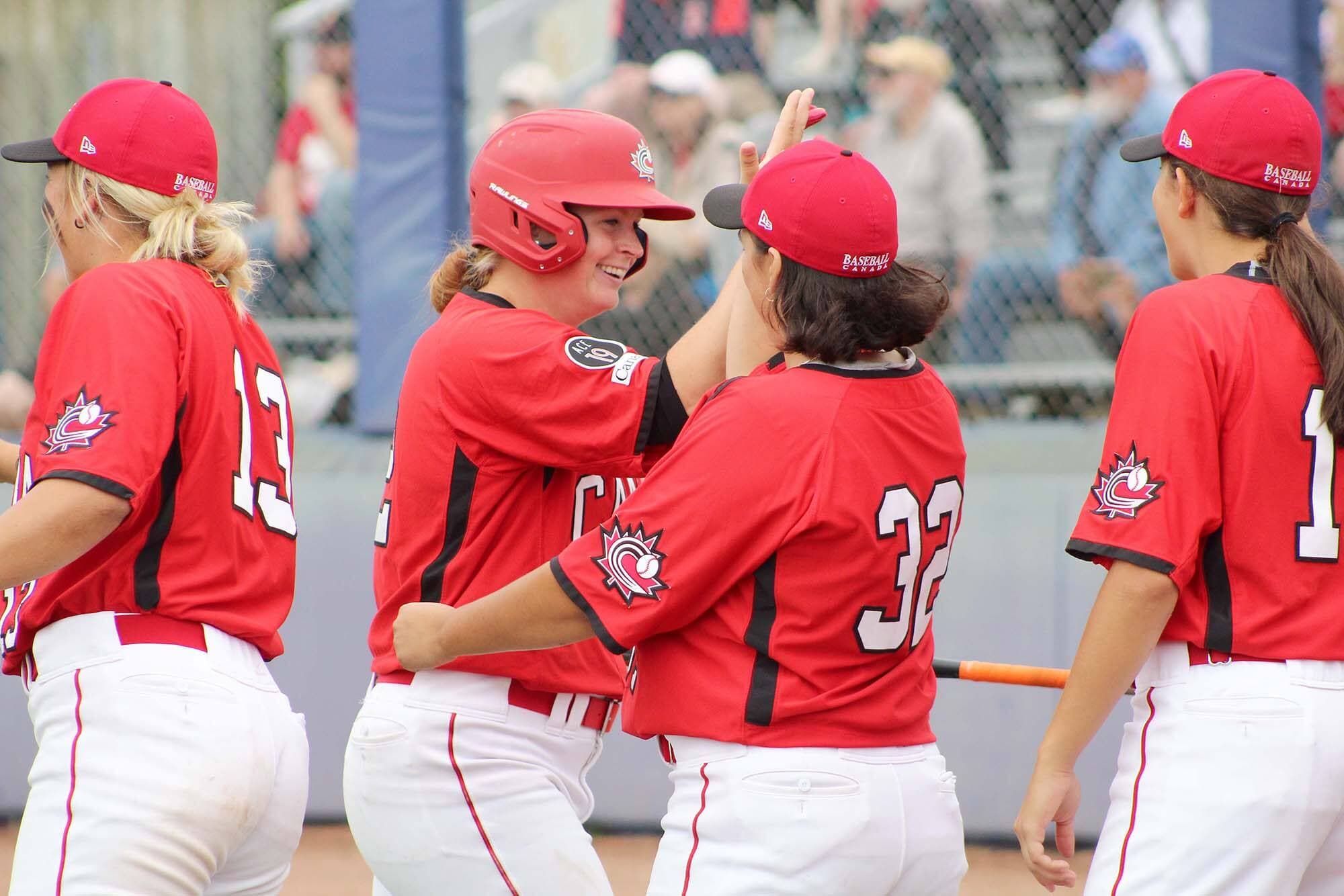 Stacy Fournier est félicitée par ses coéquipières de l’équipe féminine de baseball du Canada, Sophy Gagné et Alexane Fournier, durant la Série de l’amitié qui était disputée à Thunder Bay, en Ontario, du 28 juillet au 1er août.