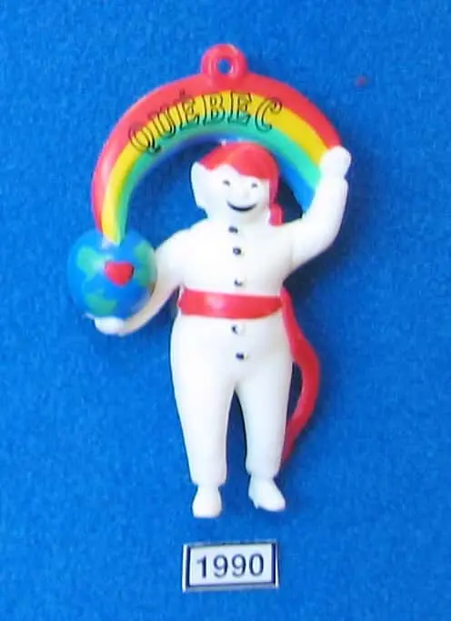 L’effigie de 1990 montre le Bonhomme qui s’ouvre sur le monde. Il tient un globe terrestre où Québec est identifiée par un cœur.