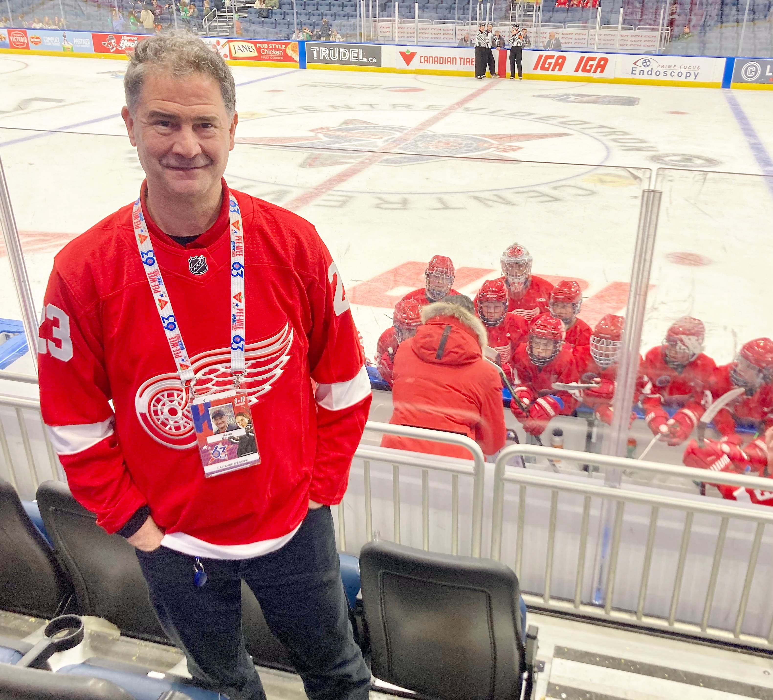 Mario Bérubé est le capitaine d’équipe des Red Wings de Detroit au Tournoi pee-wee. Il est impliqué auprès de la formation depuis 25 ans. On le voit prendre la pose derrière le banc du club au Centre Vidéotron.