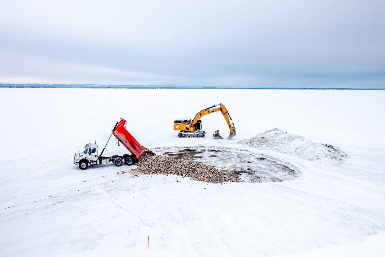 Ces machineries semblent bien petites sur l’immensité des glaces du lac Saint-Jean.