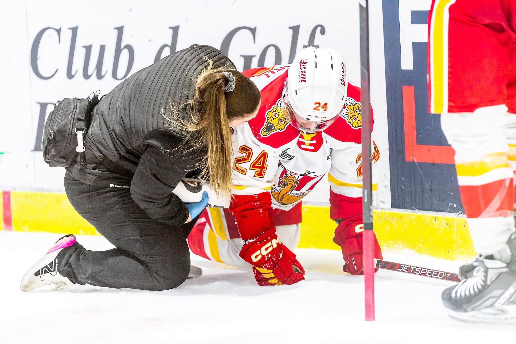 La thérapeute du sport en chef du Drakkar de Baie-Comeau, Mariane Allard, vient en aide à un joueur de l’équipe blessé sur la patinoire, durant un match.
