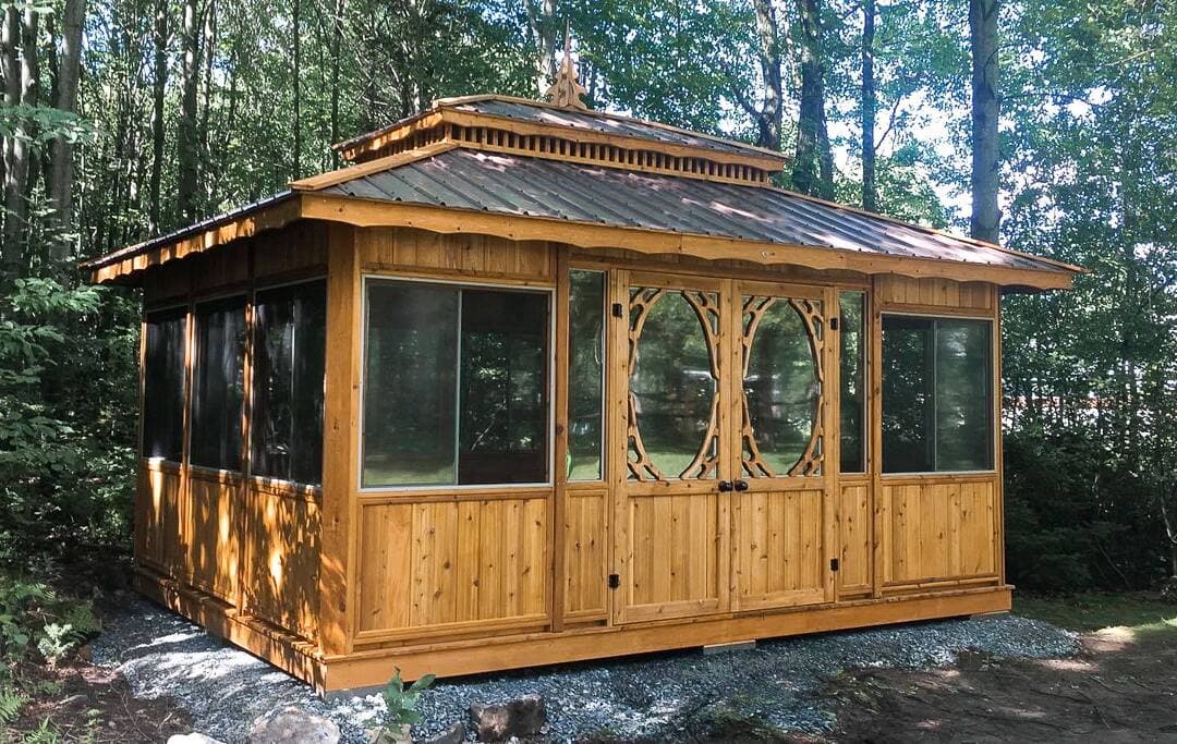 Gazebo fermé en bois de cèdre modèle Intimité avec moustiquaires, fenêtres de polymère et toiture en tôle de l’entreprise Gazébec.