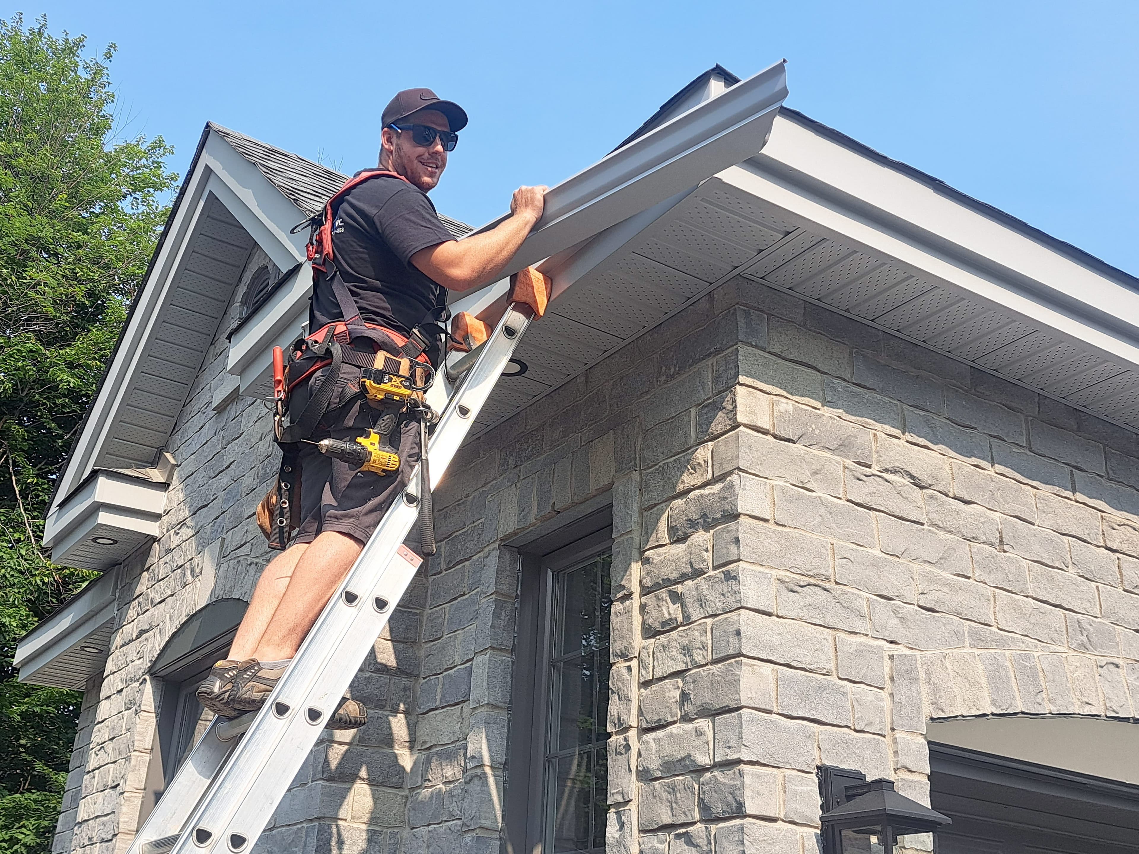 Jérémy Boudreau, propriétaire de Gouttières Aluminium JB, pose les gouttières d’une maison neuve à Saint-Lazarre.